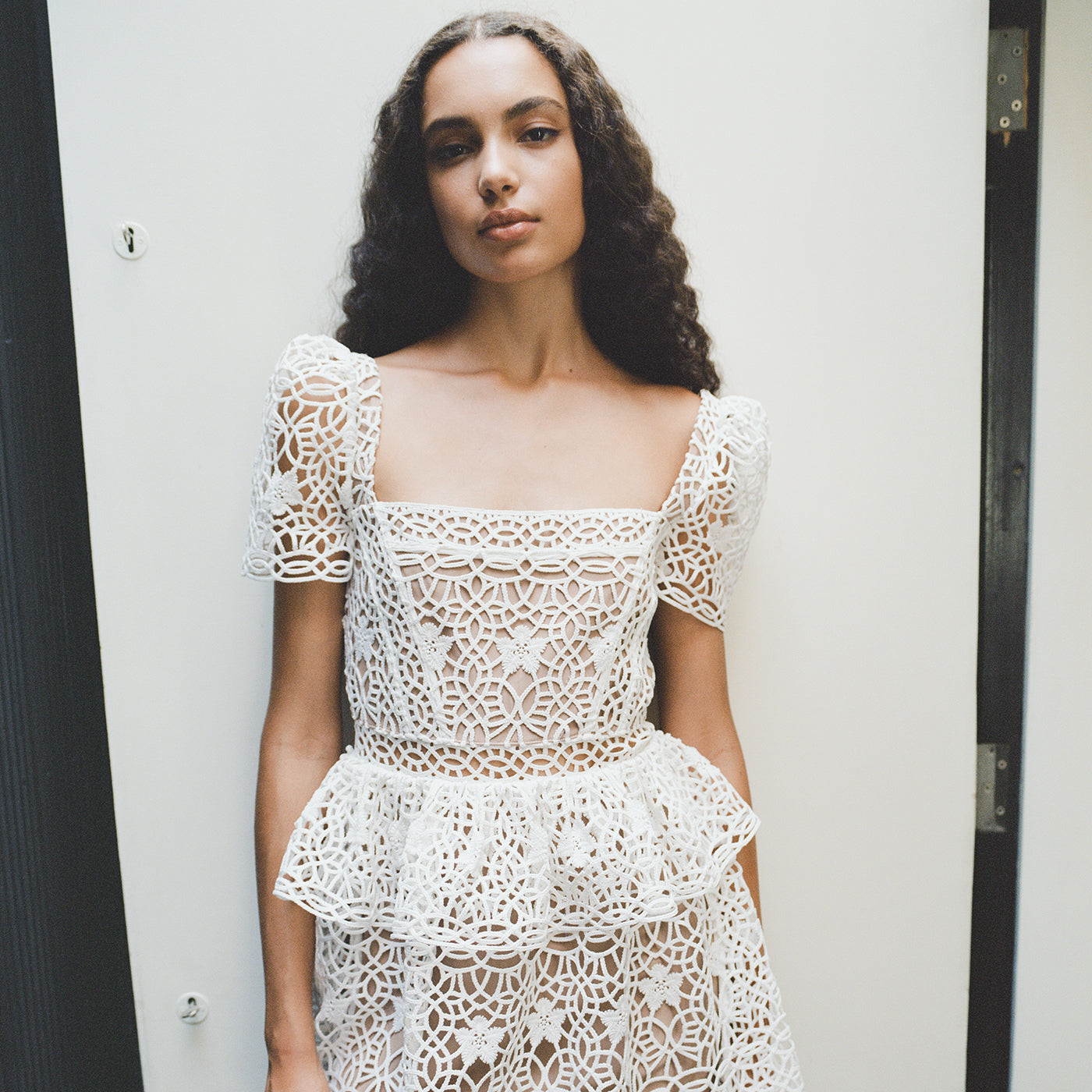 A woman wearing the White Guipure Lace Tiered Mini Dress