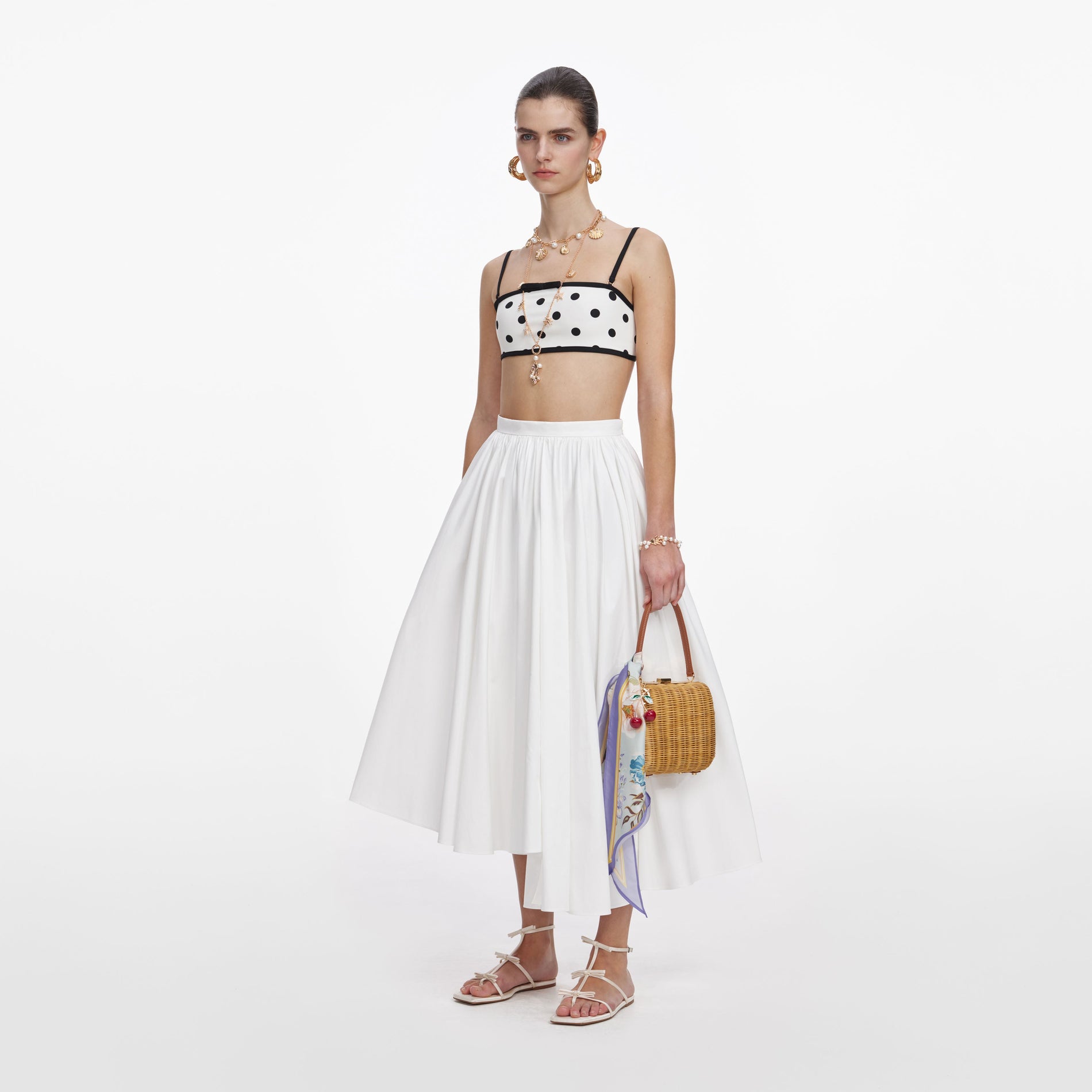 Side view of a woman wearing the White Polka Dot Bikini Top