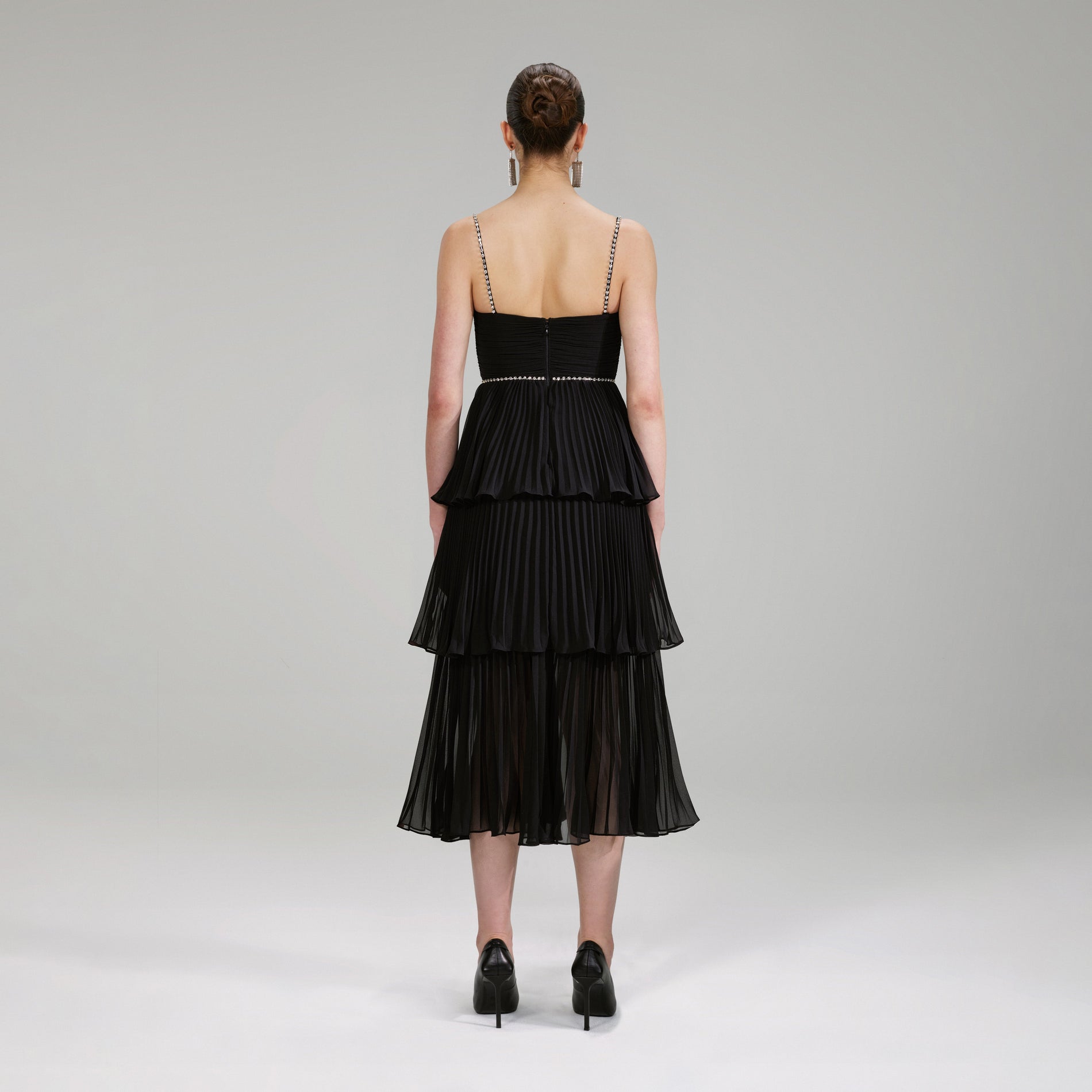 A woman wearing the Black Chiffon Tiered Midi Dress