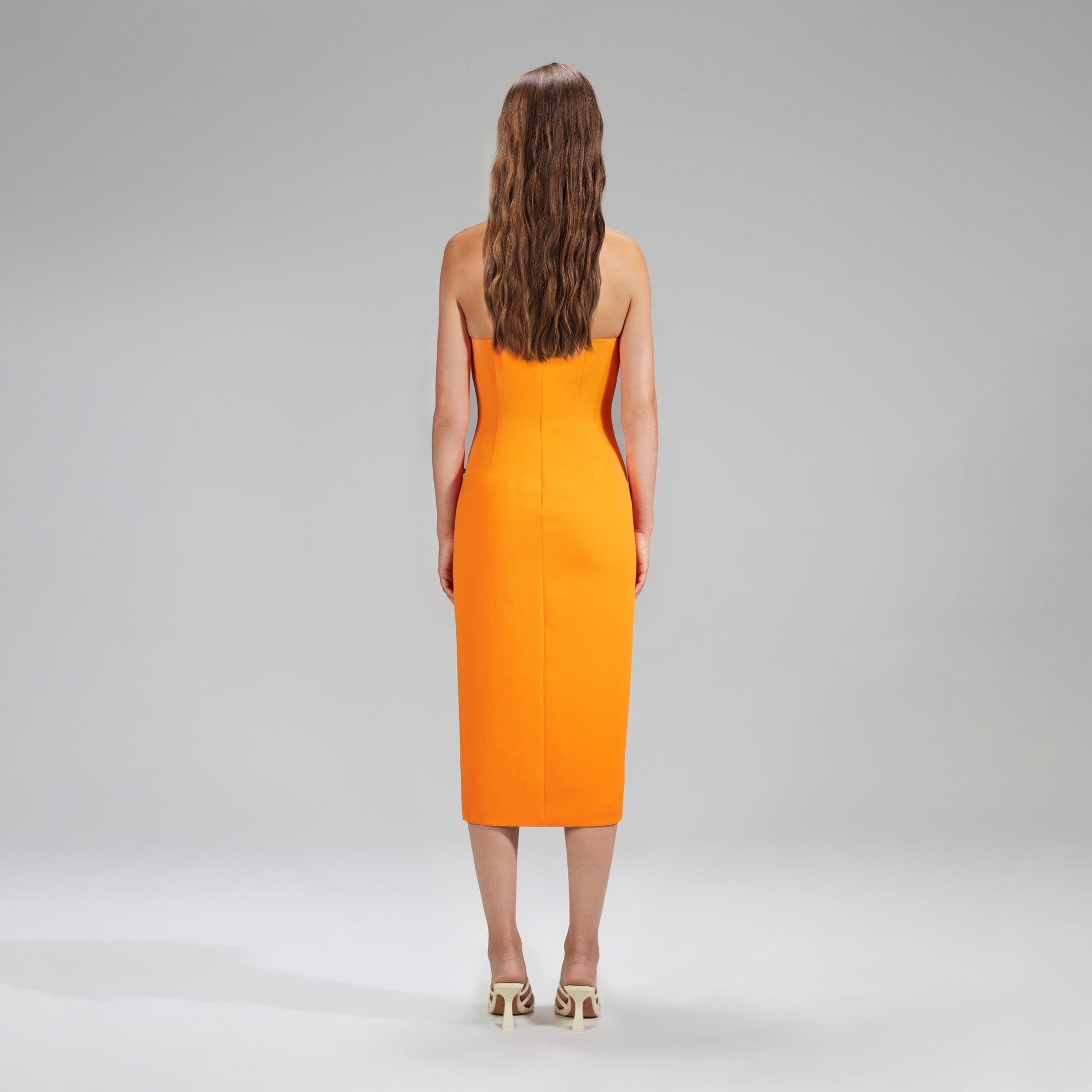 A woman wearing the Orange Crepe Midi Dress With Trim