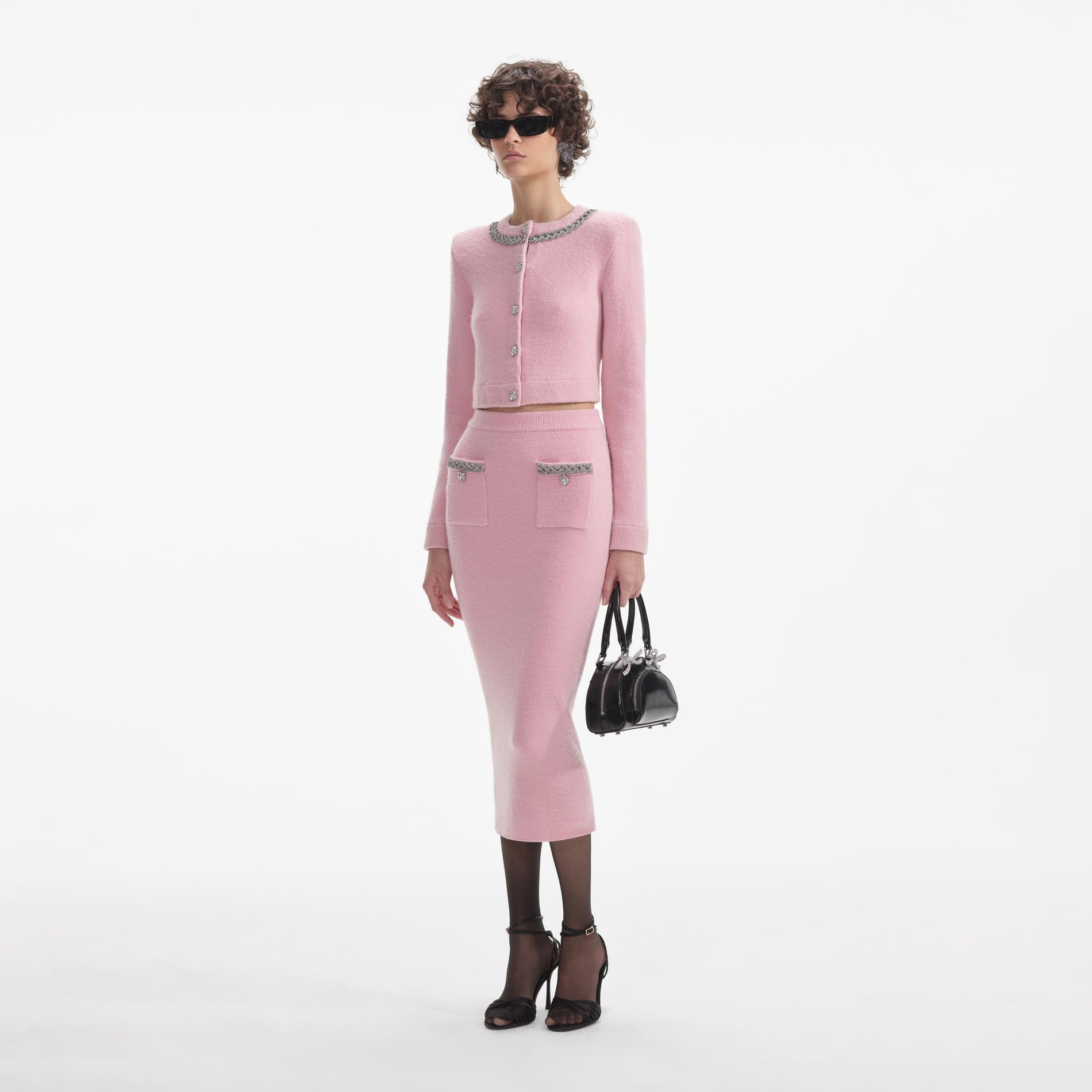 Side view of a woman wearing the Pink Embellished Knit Midi Skirt