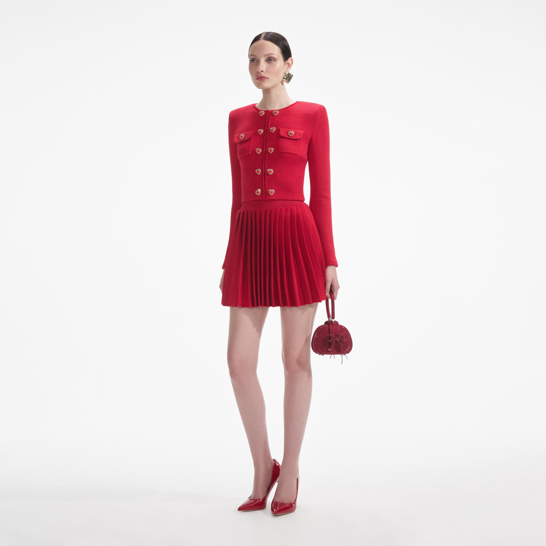 Side view of a woman wearing the Red Pleated Knit Mini Skirt