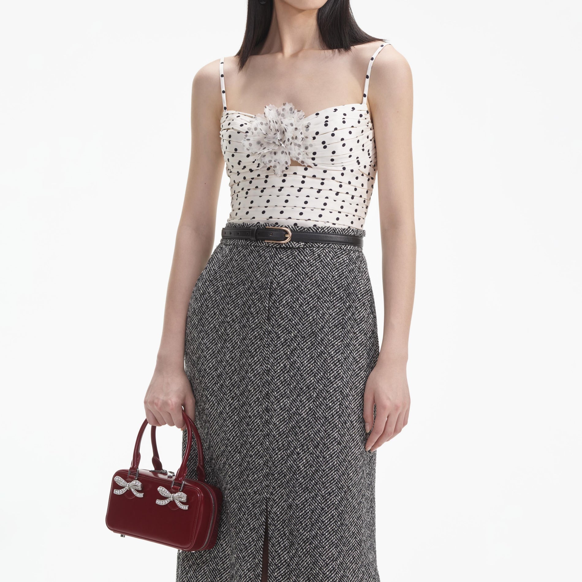 A close up of a woman wearing the Black Herringbone Midi Skirt