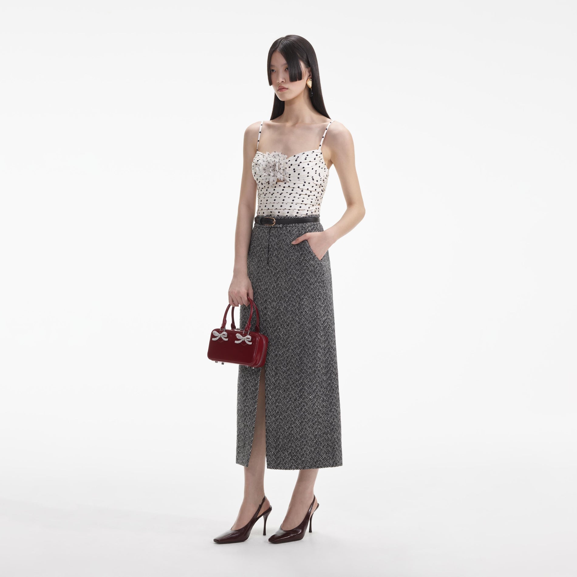 Side view of a woman wearing the Black Herringbone Midi Skirt