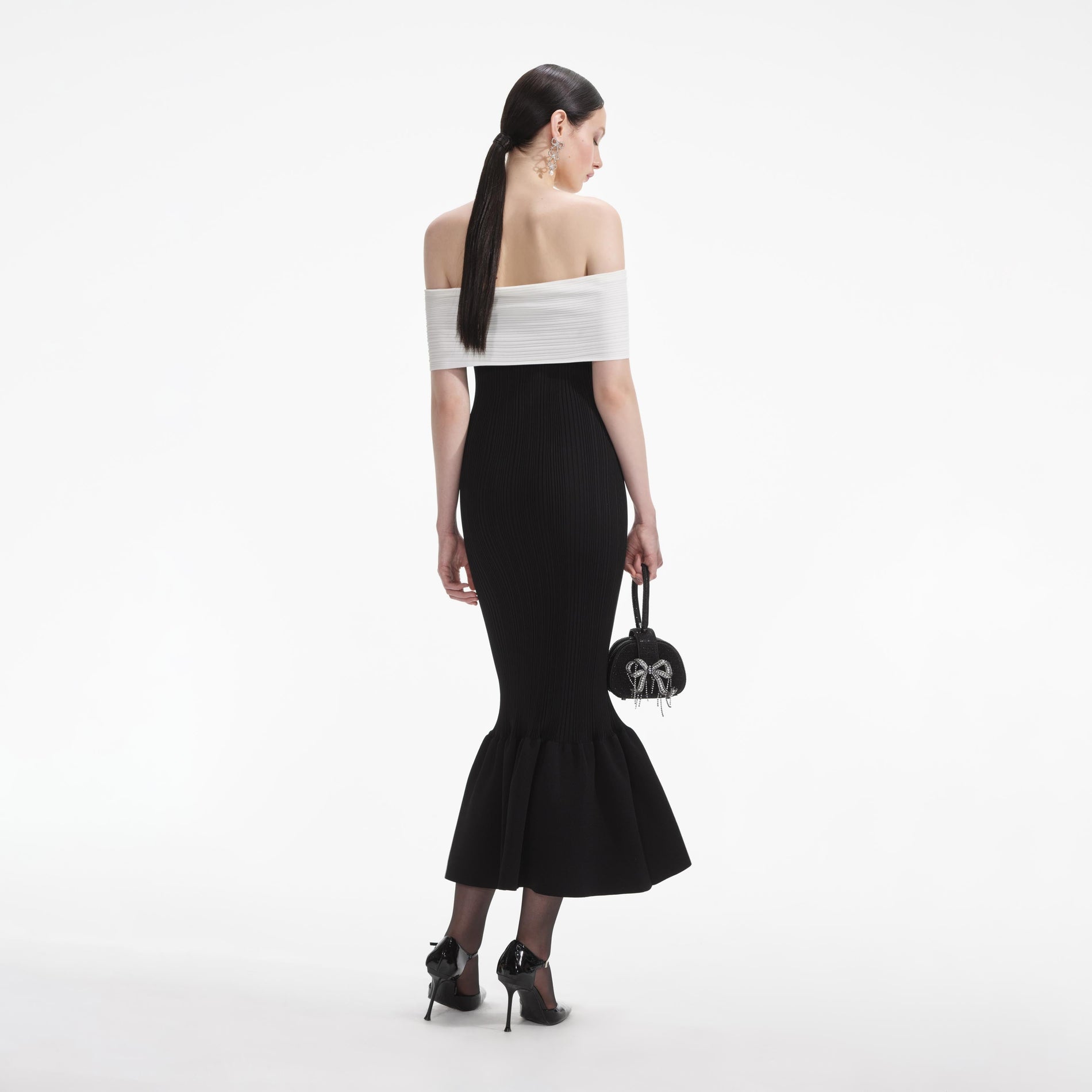 Back view of a woman wearing the White Black Knit Bow Midi Dress