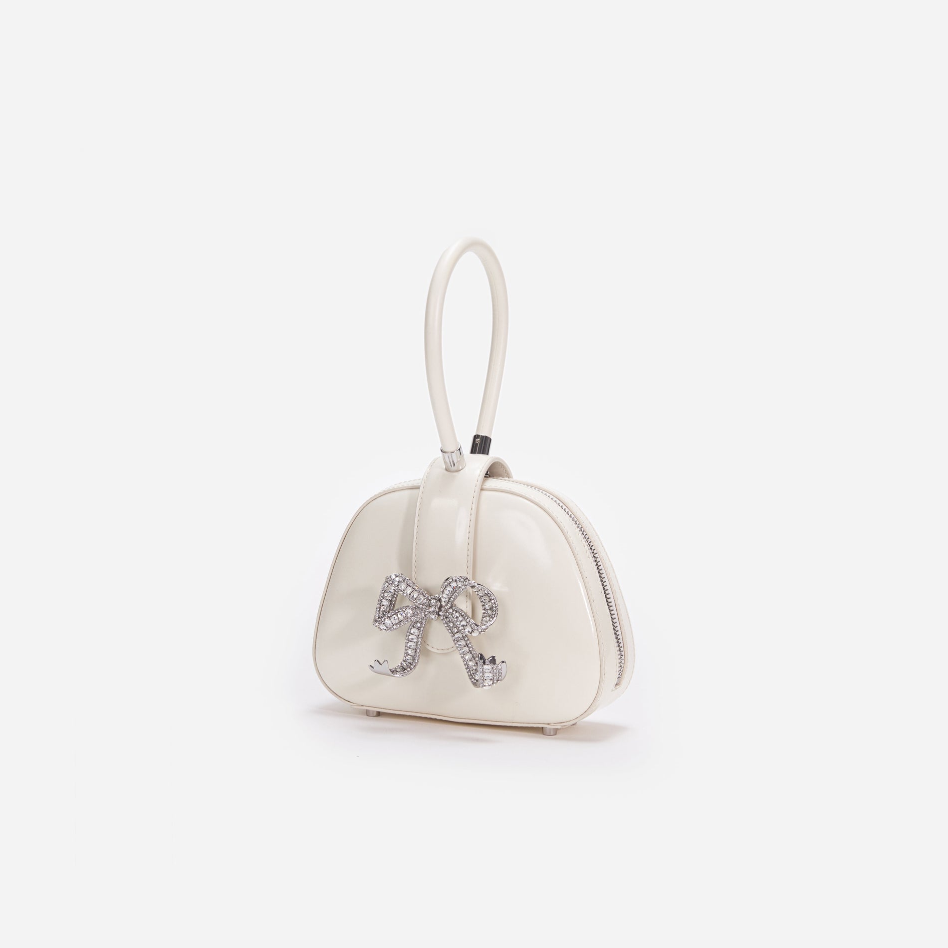 Side view of a woman wearing the Cream Leather Top Handle Mini Bag