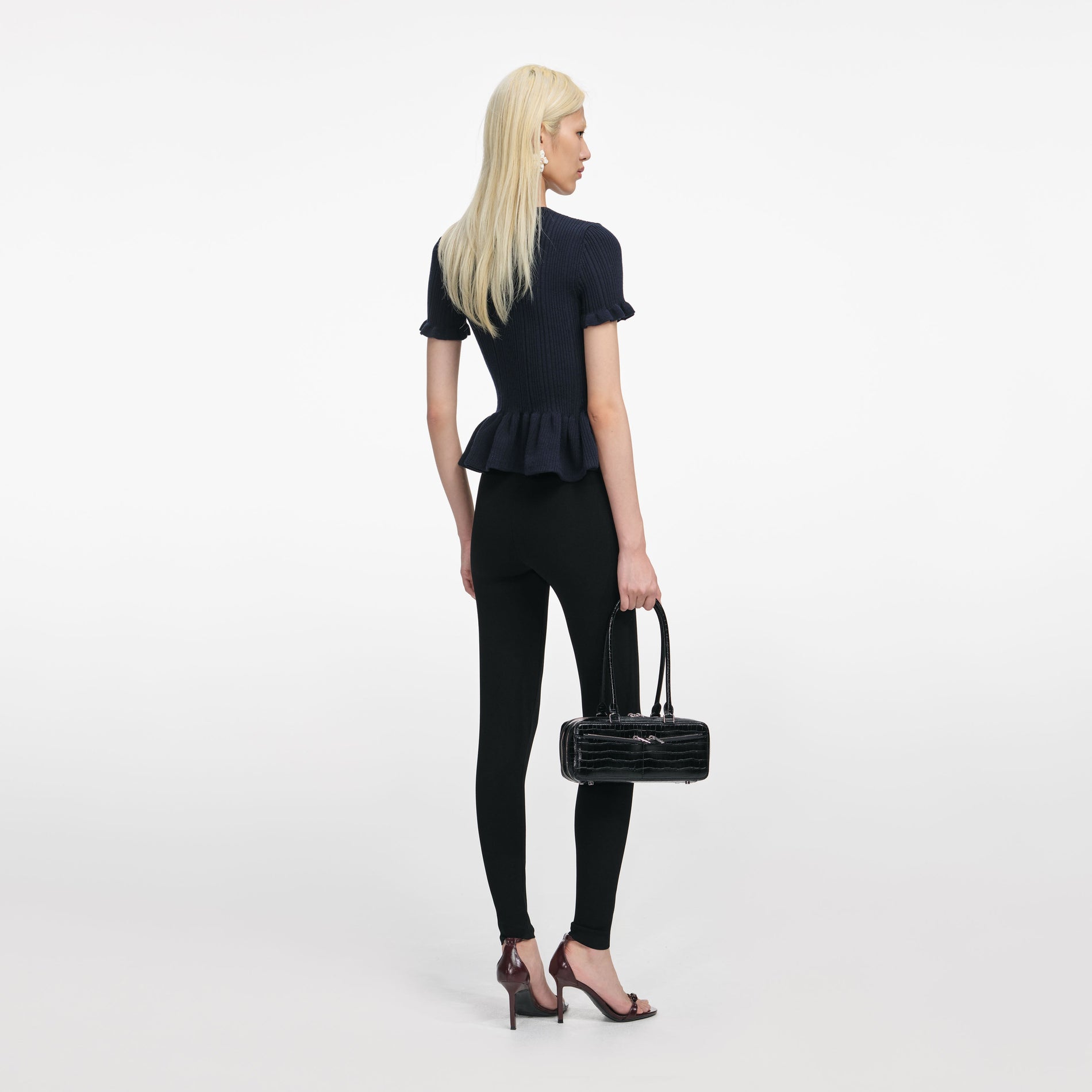 Back view of a woman wearing the Navy Asymmetric Knit Top