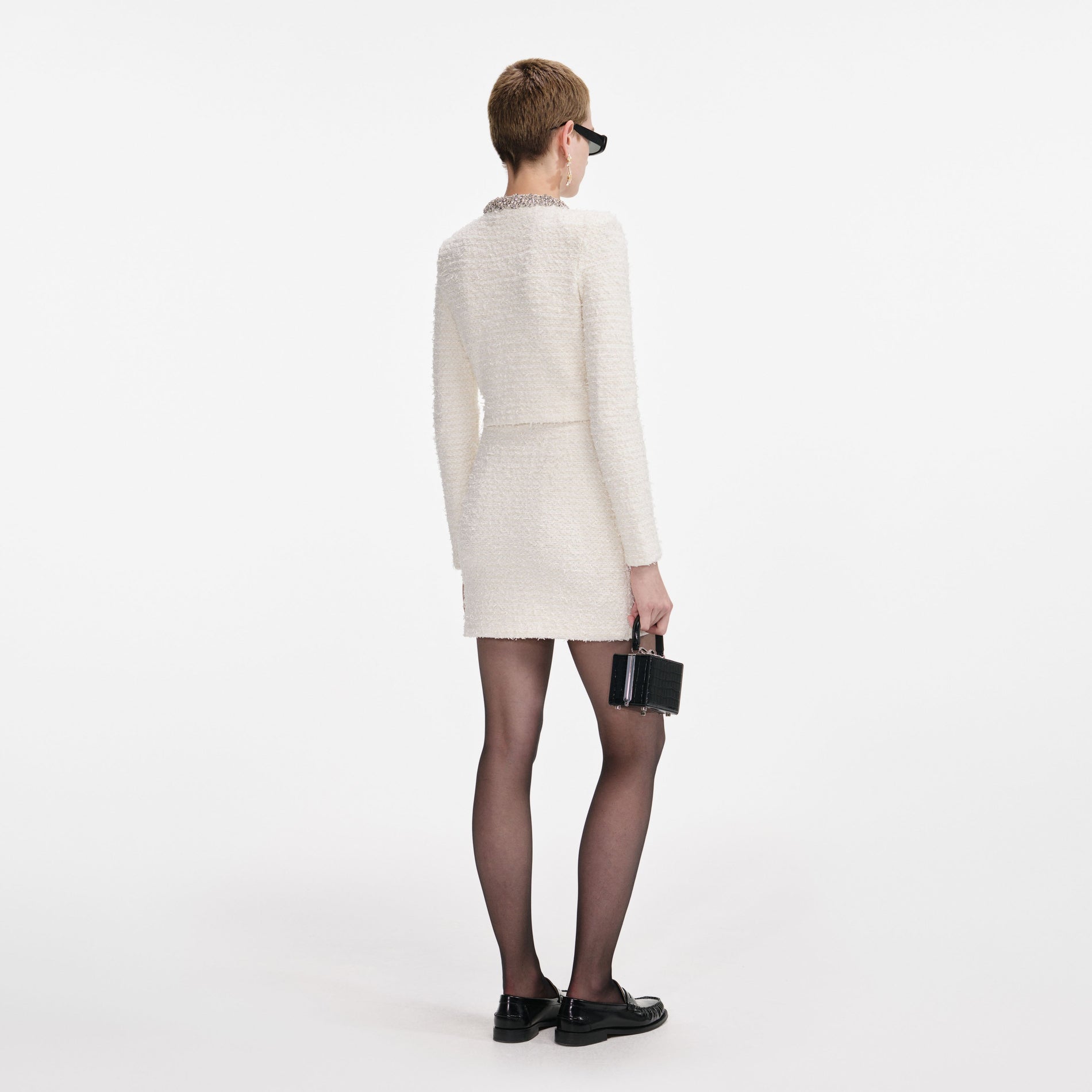 Back view of a woman wearing the Cream Textured Knit Mini Skirt