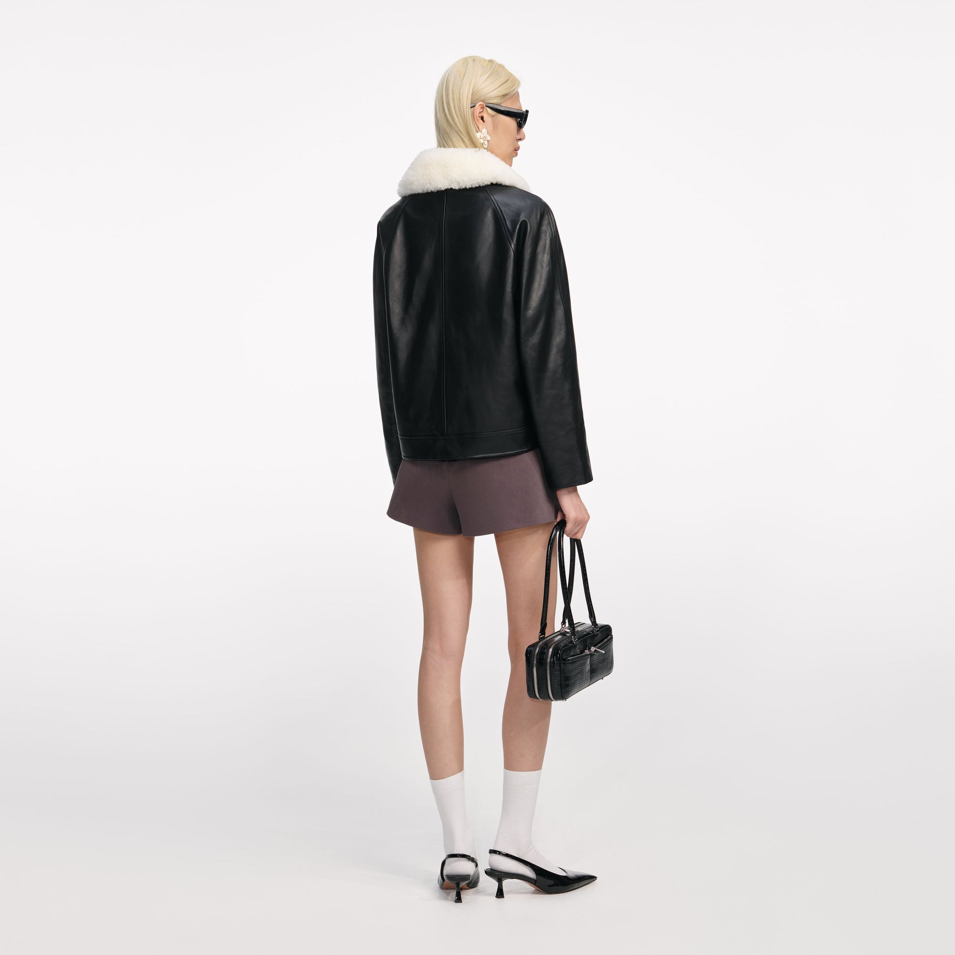 Back view of a woman wearing the Black Leather Fur Collar Jacket