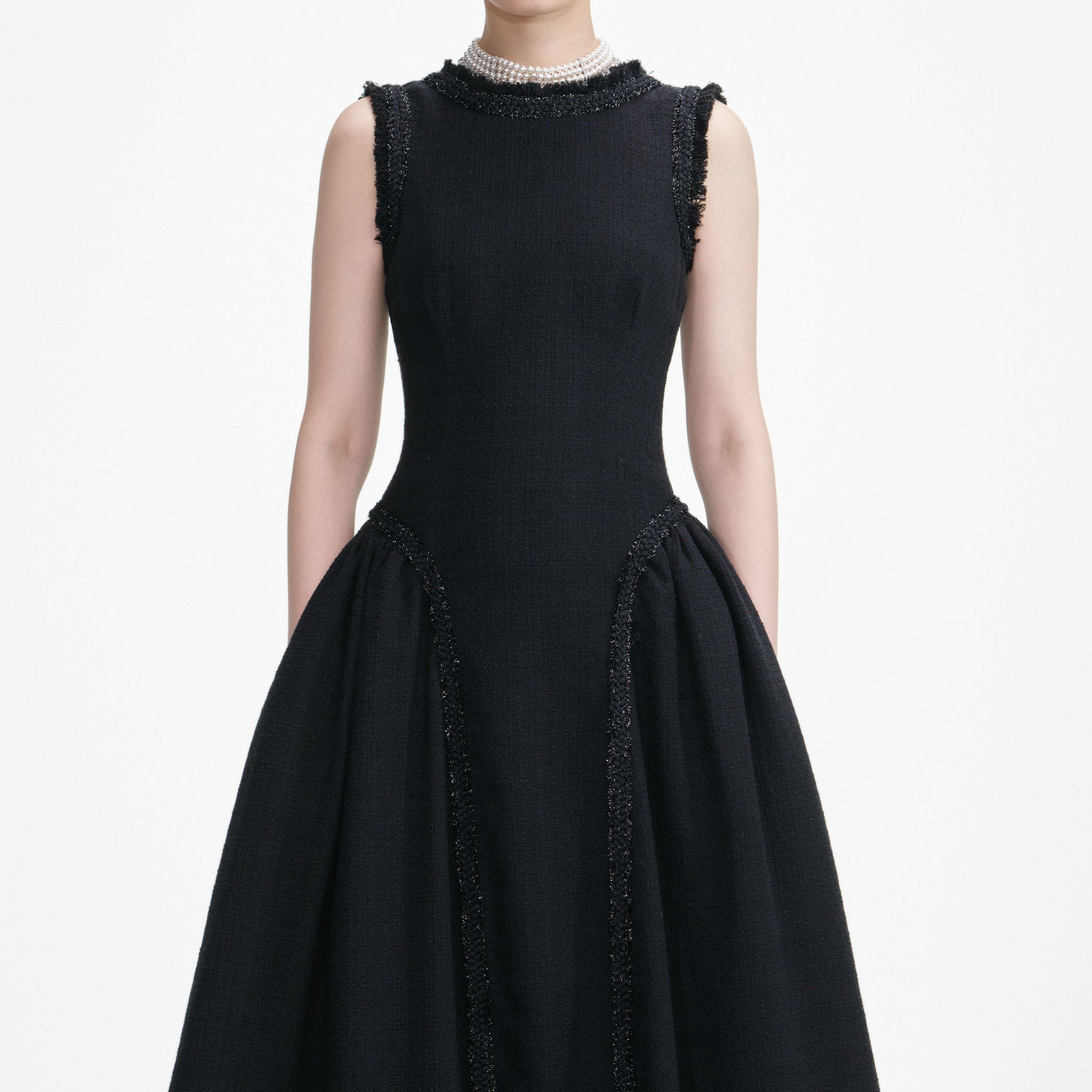 A close up of a woman wearing the Black Boucle Sleeveless Midi Dress