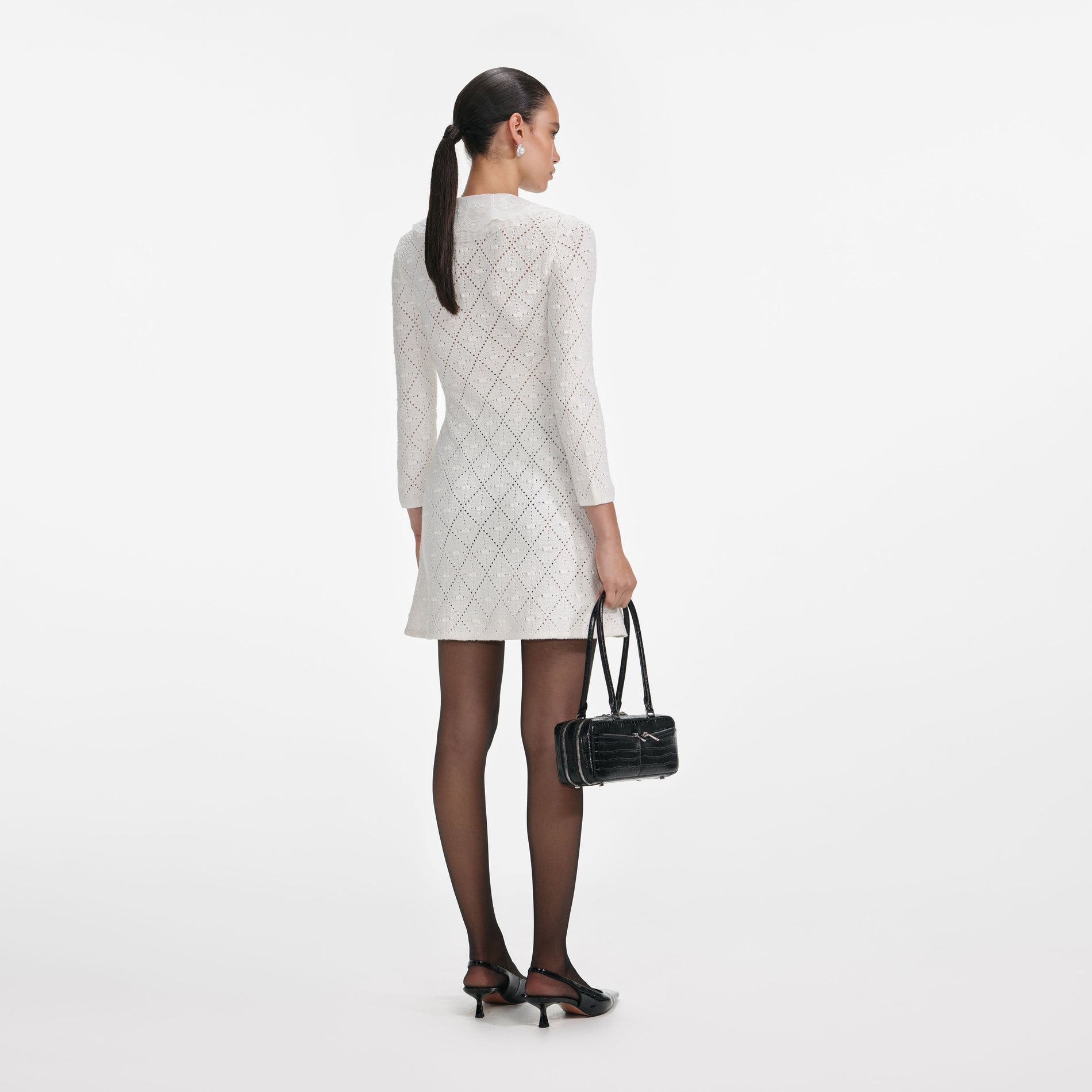 Back view of a woman wearing the White Lace Bib Knit Mini Dress