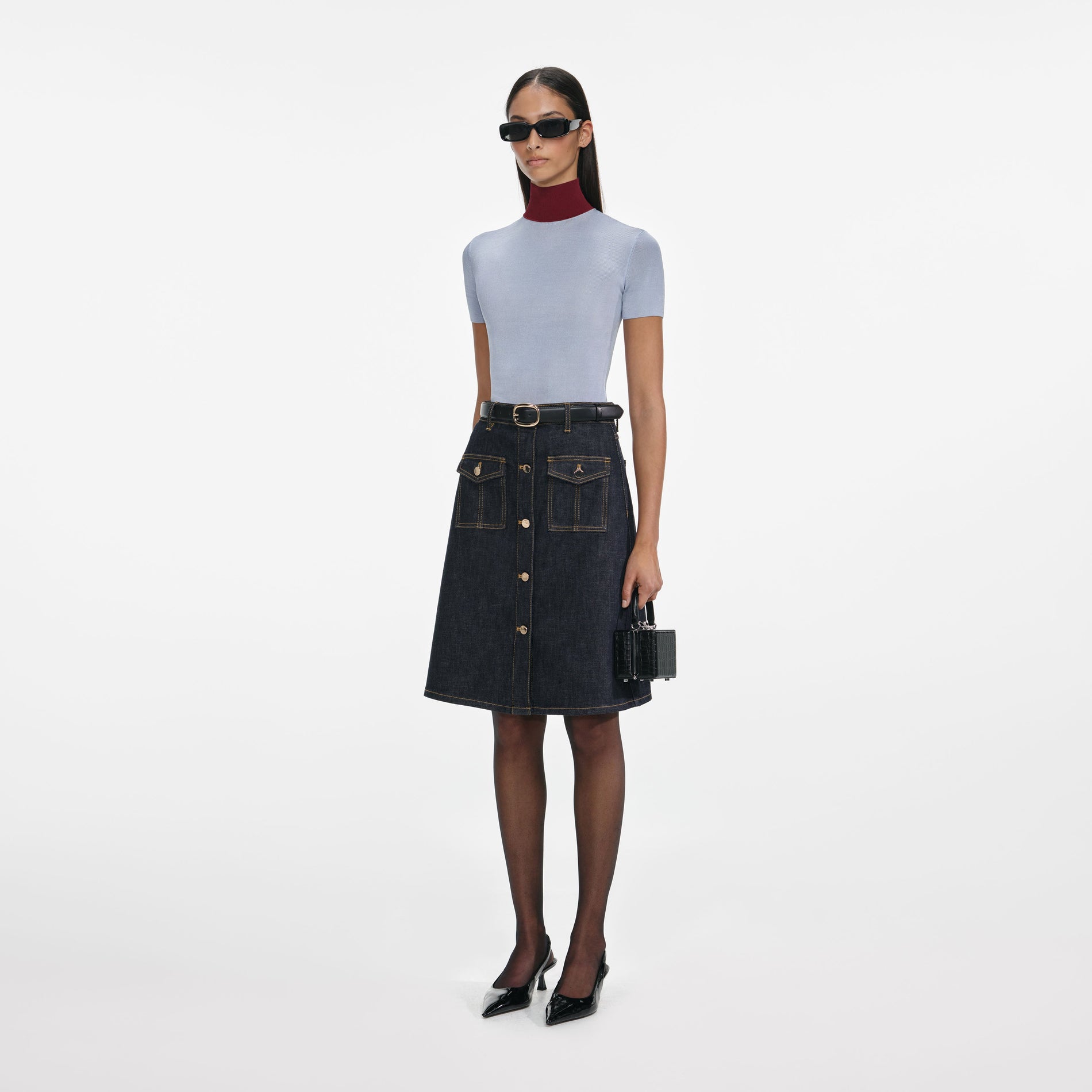 Side view of a woman wearing the Indigo Denim Belted Midi Skirt