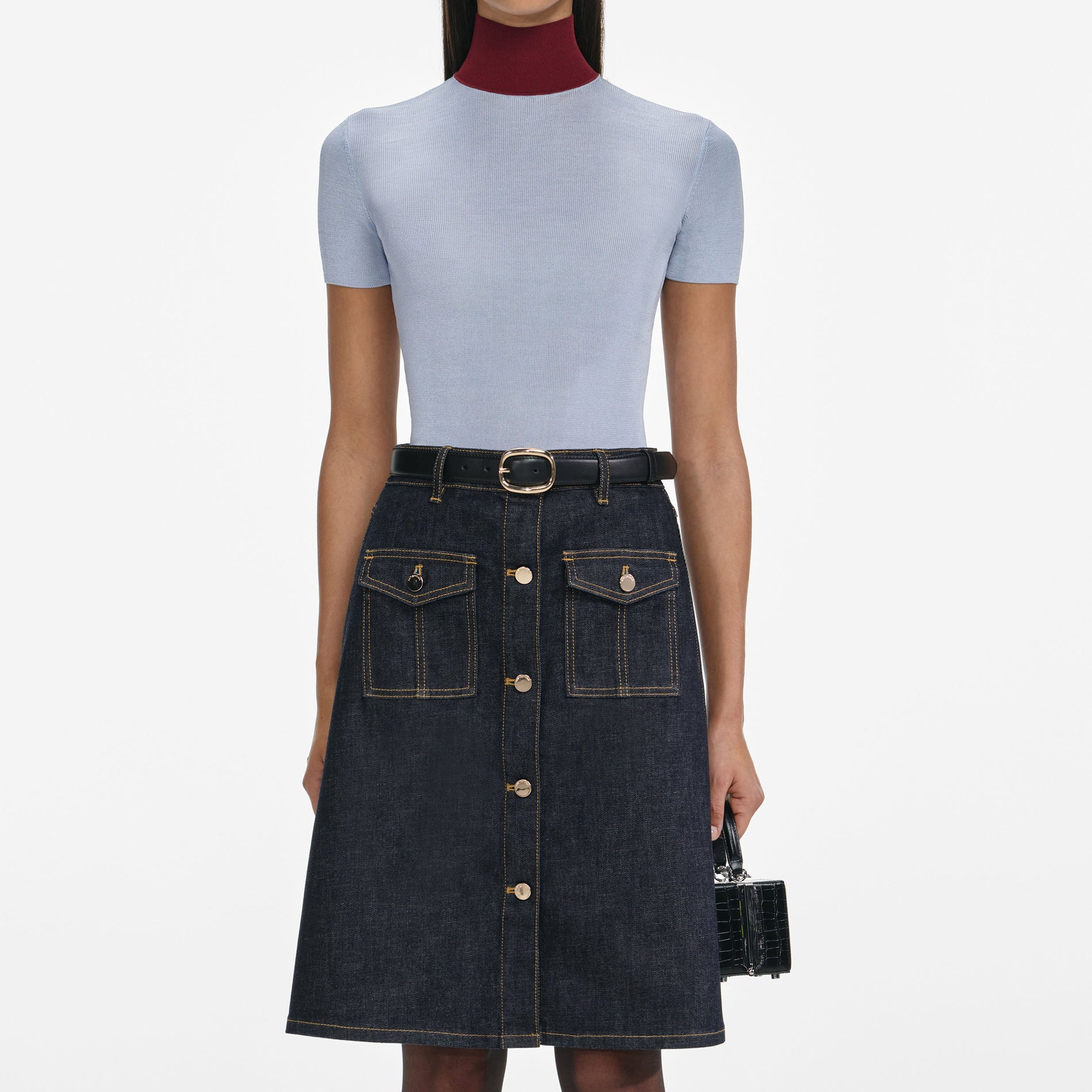 A close up of a woman wearing the Indigo Denim Belted Midi Skirt
