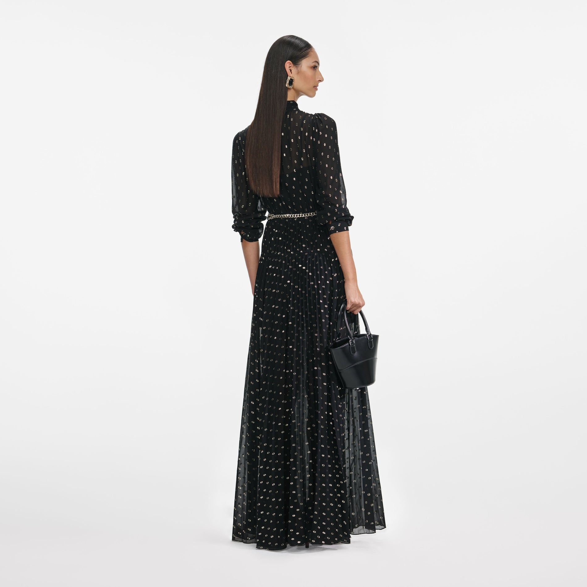 Back view of a woman wearing the Black And Gold Pussy Bow Maxi Dress