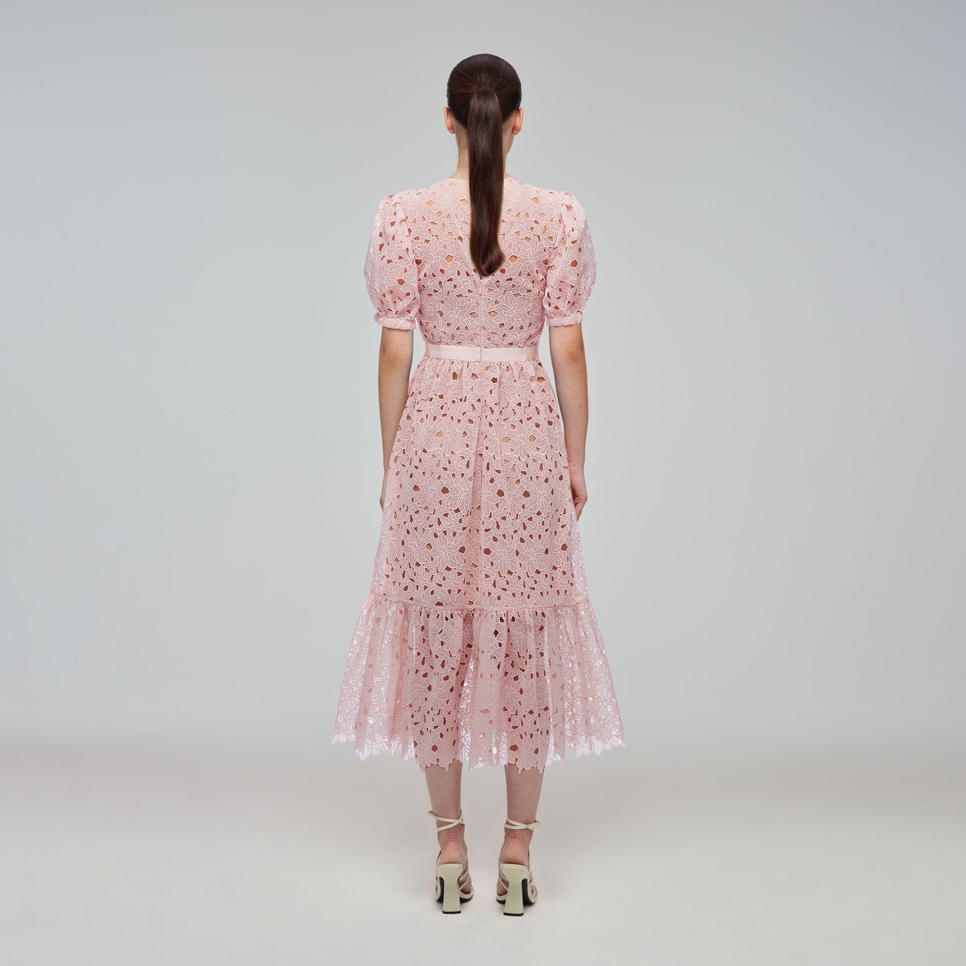 A woman wearing the Blush Guipure Midi Dress