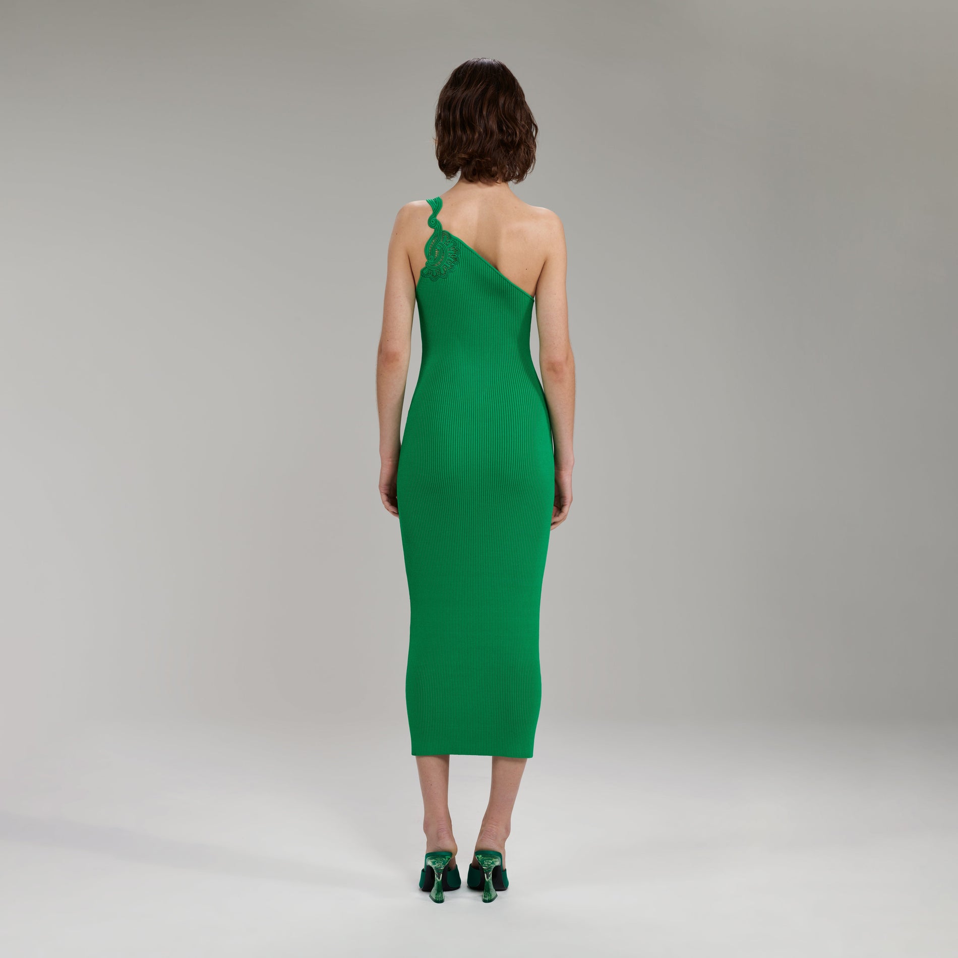 A woman wearing the Bright Green One Shoulder Ribbed Knit Midi Dress