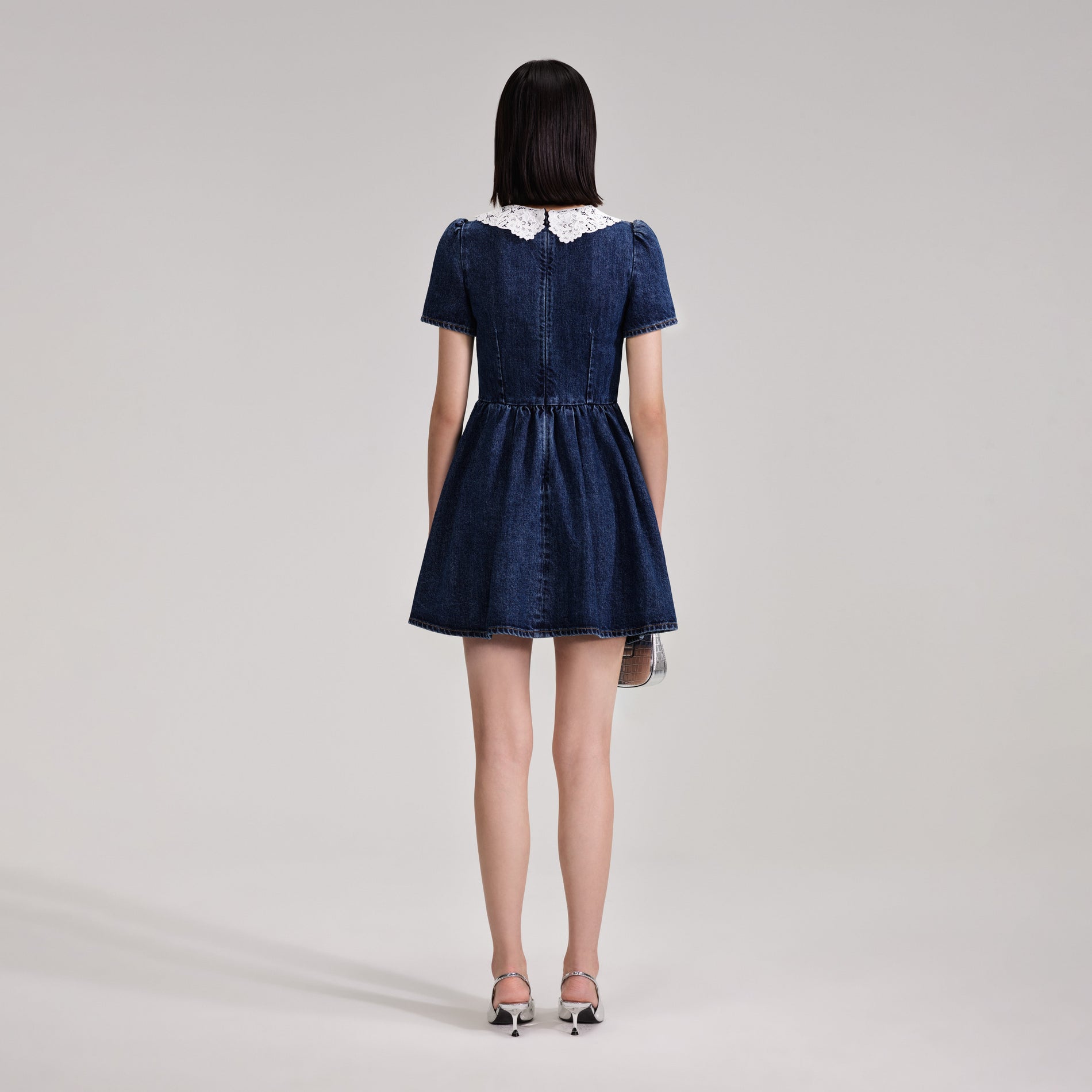 A woman wearing the Lace Collar Denim Mini Dress