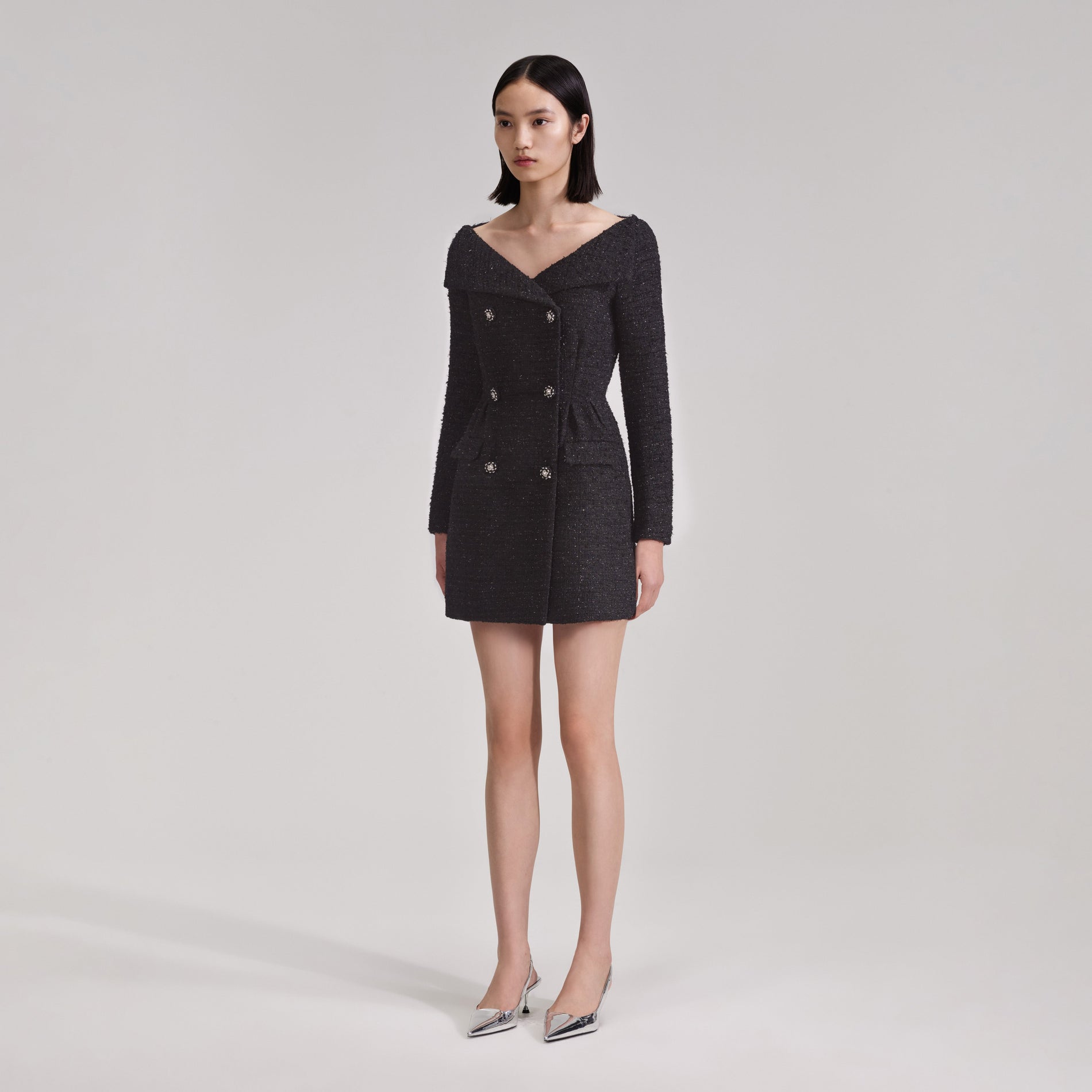 A woman wearing the Black Off Shoulder Boucle Mini Dress