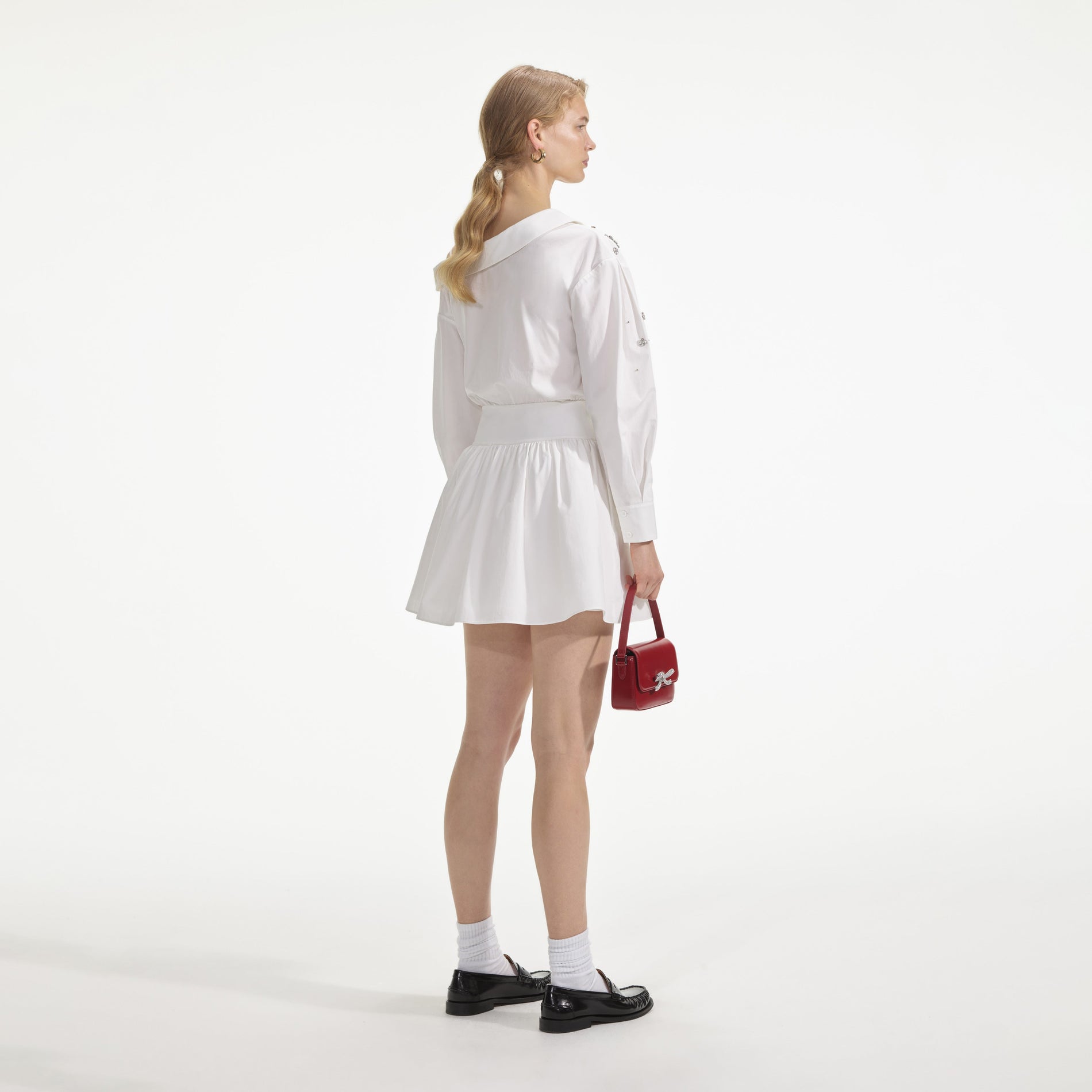 Back view of a woman wearing the White Cotton Embellished Mini Dress