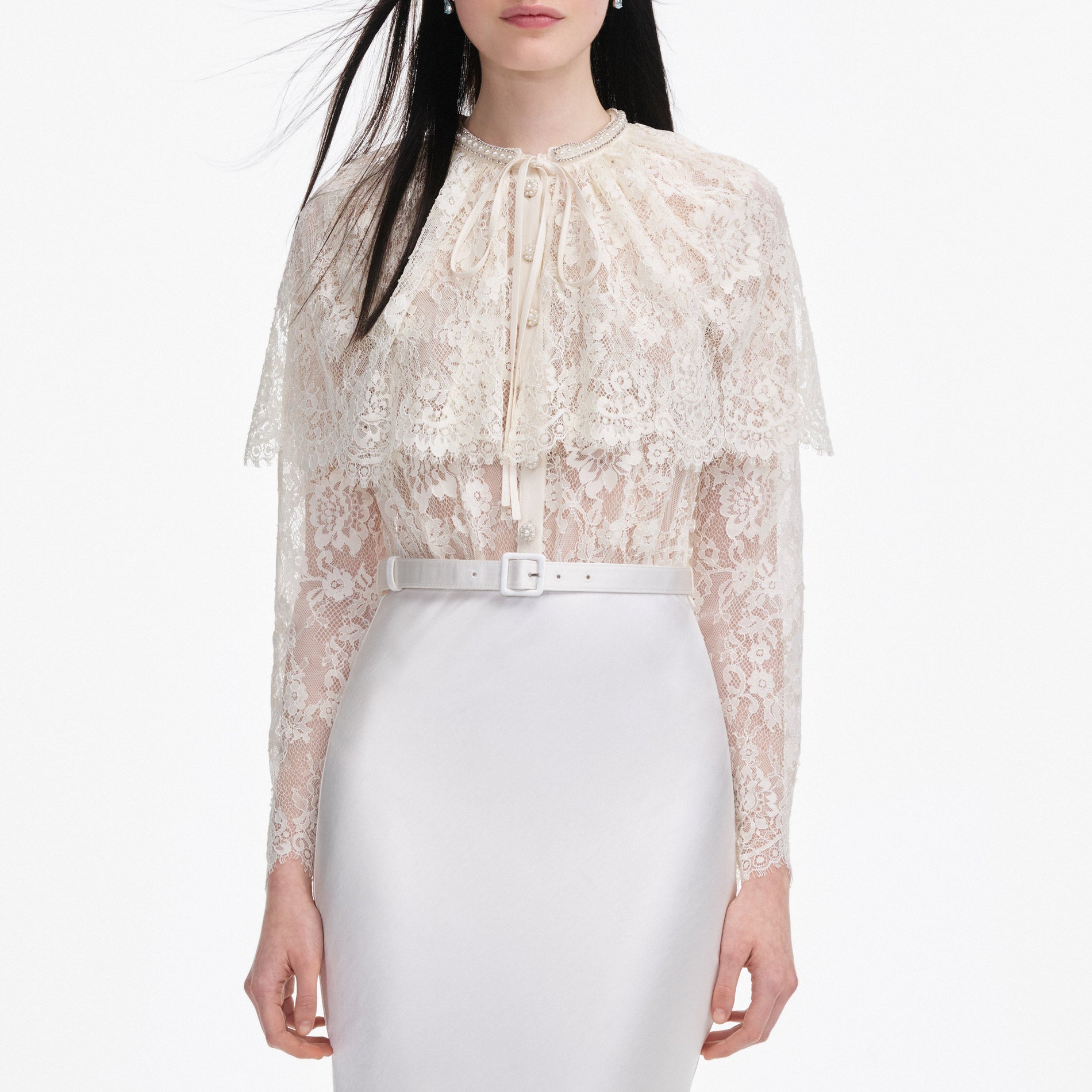 A close up of a woman wearing the White Lace Cape Maxi Dress