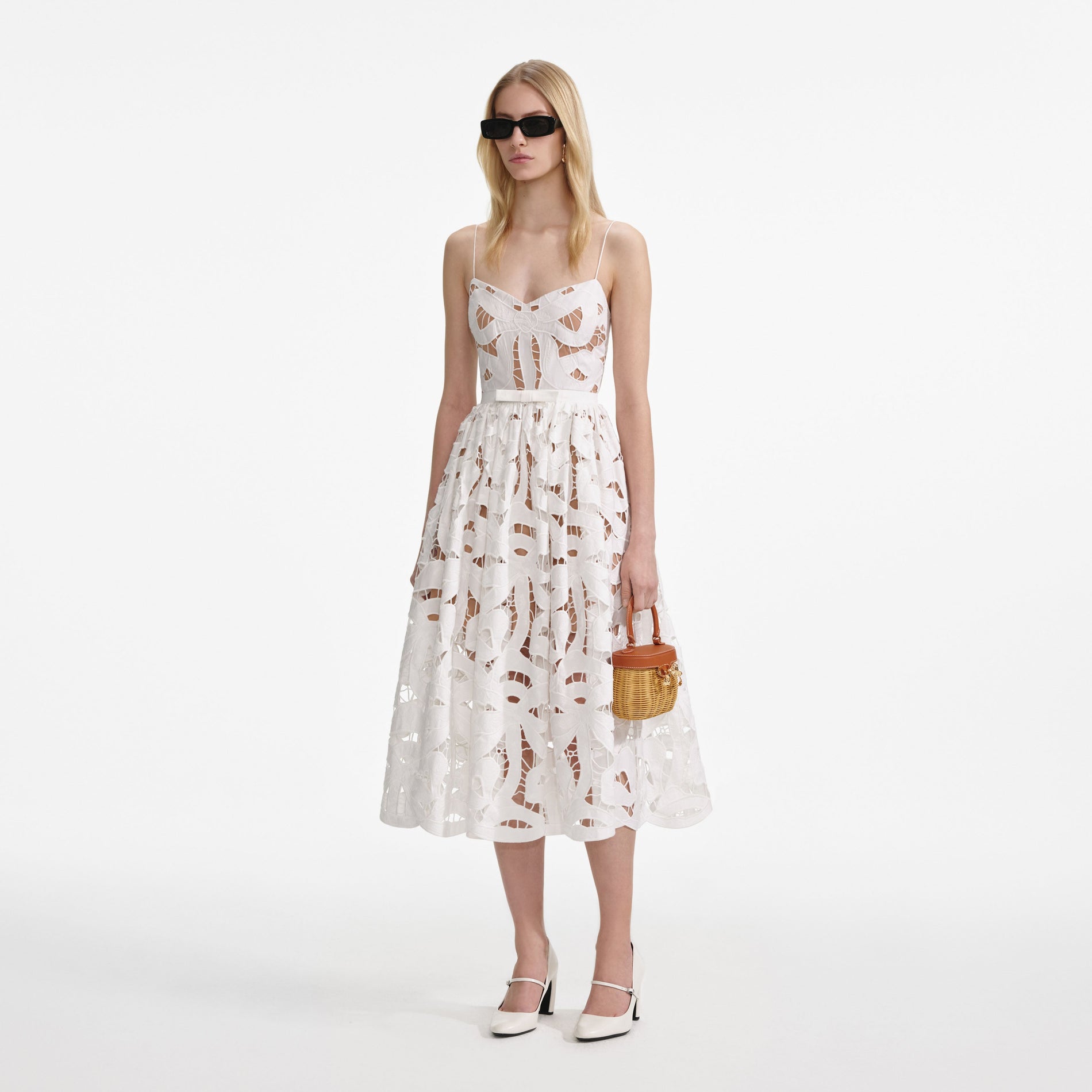 Side view of a woman wearing the White Bow Embroidered Midi Dress