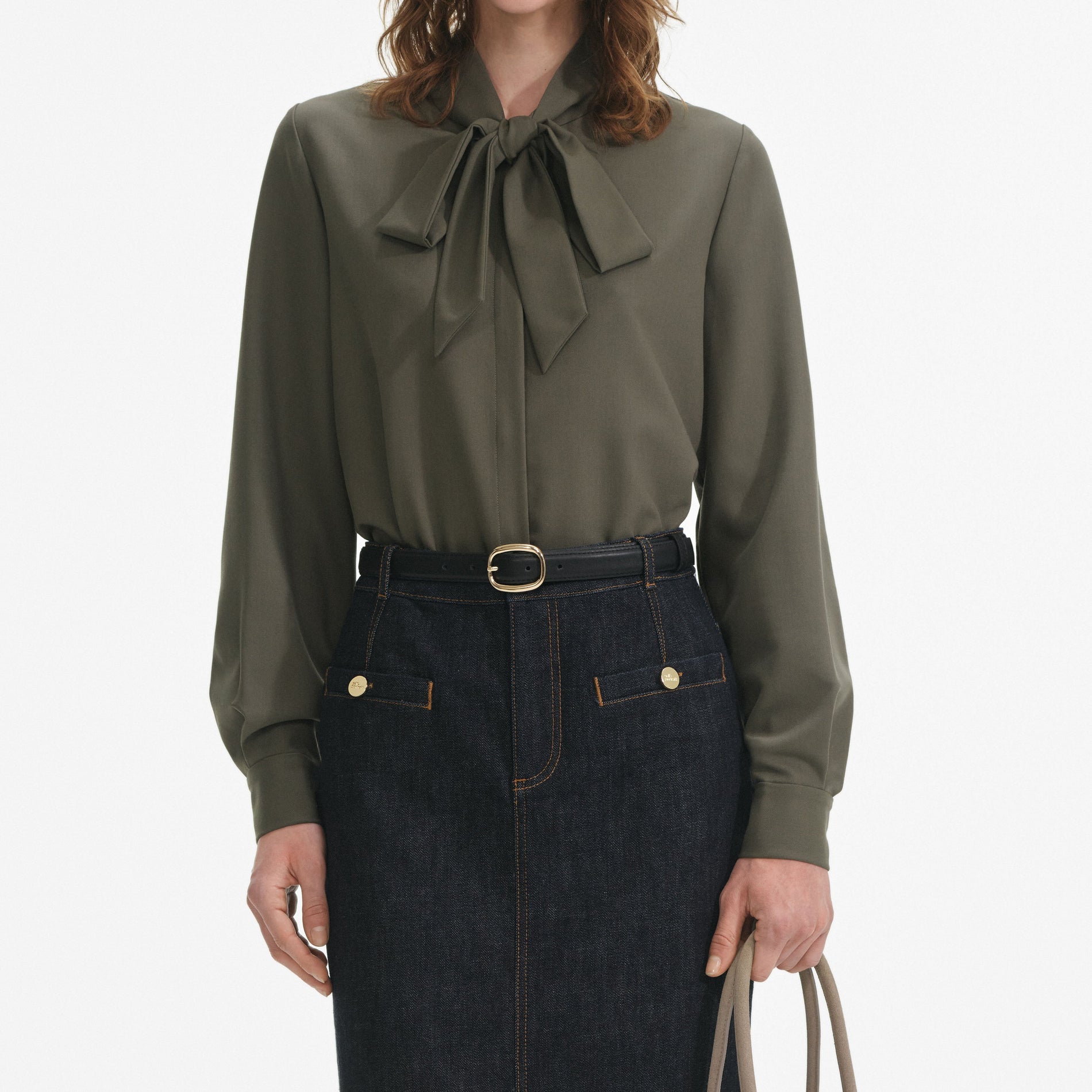 A close up of a woman wearing the Khaki Twill Pussy Bow Blouse