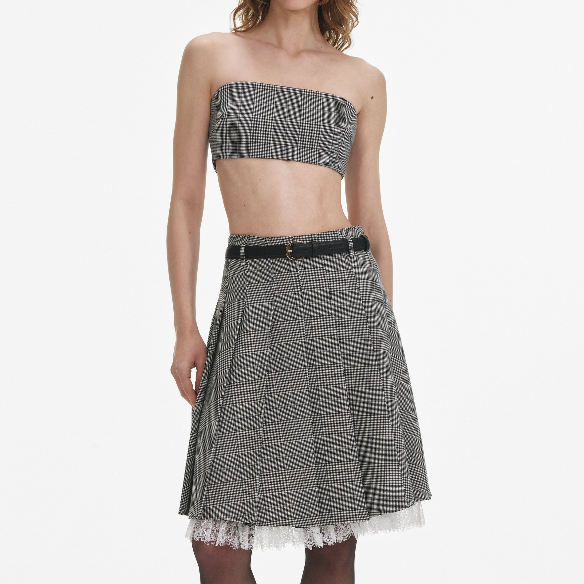 A close up of a woman wearing the Prince Of Wales Check Pleated Midi Skirt