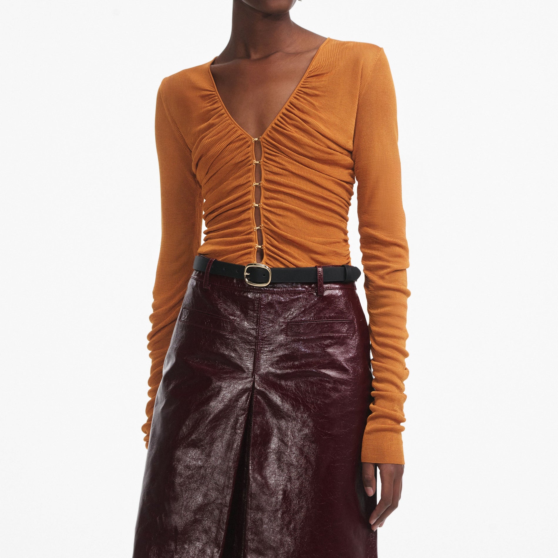A close up of a woman wearing the Burnt Orange V Neck Viscose Knit Top