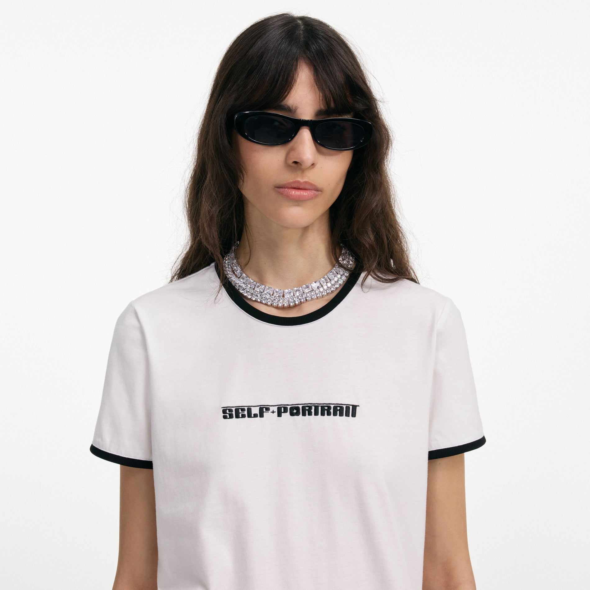 A close up of a woman wearing the White T-Shirt With Embroidered Logo