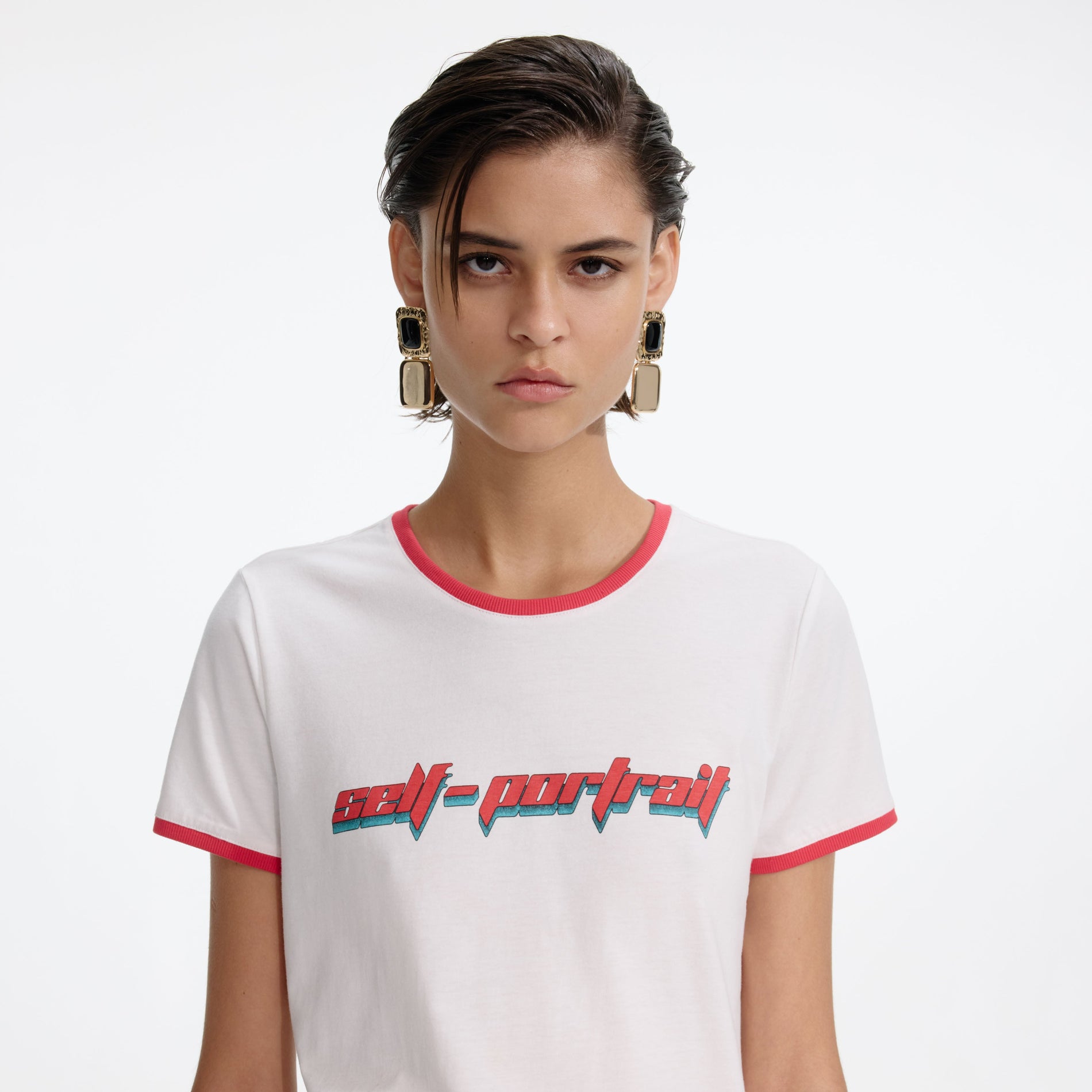 A close up of a woman wearing the White T-Shirt With Red Logo