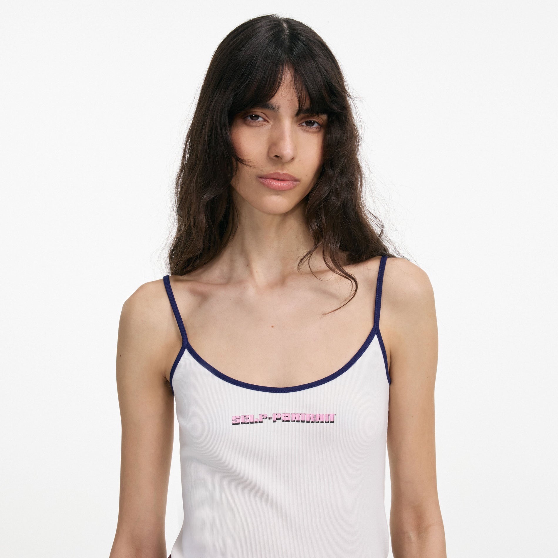 A close up of a woman wearing the White Vest With Pink Logo