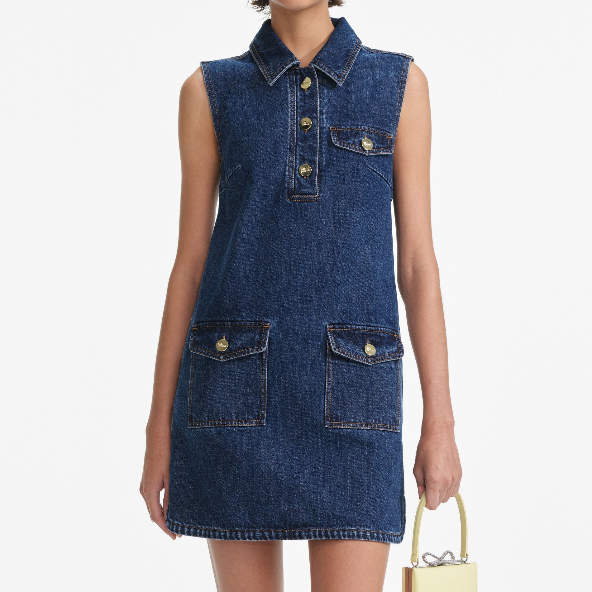 A close up of a woman wearing the Denim Sleeveless Mini Dress
