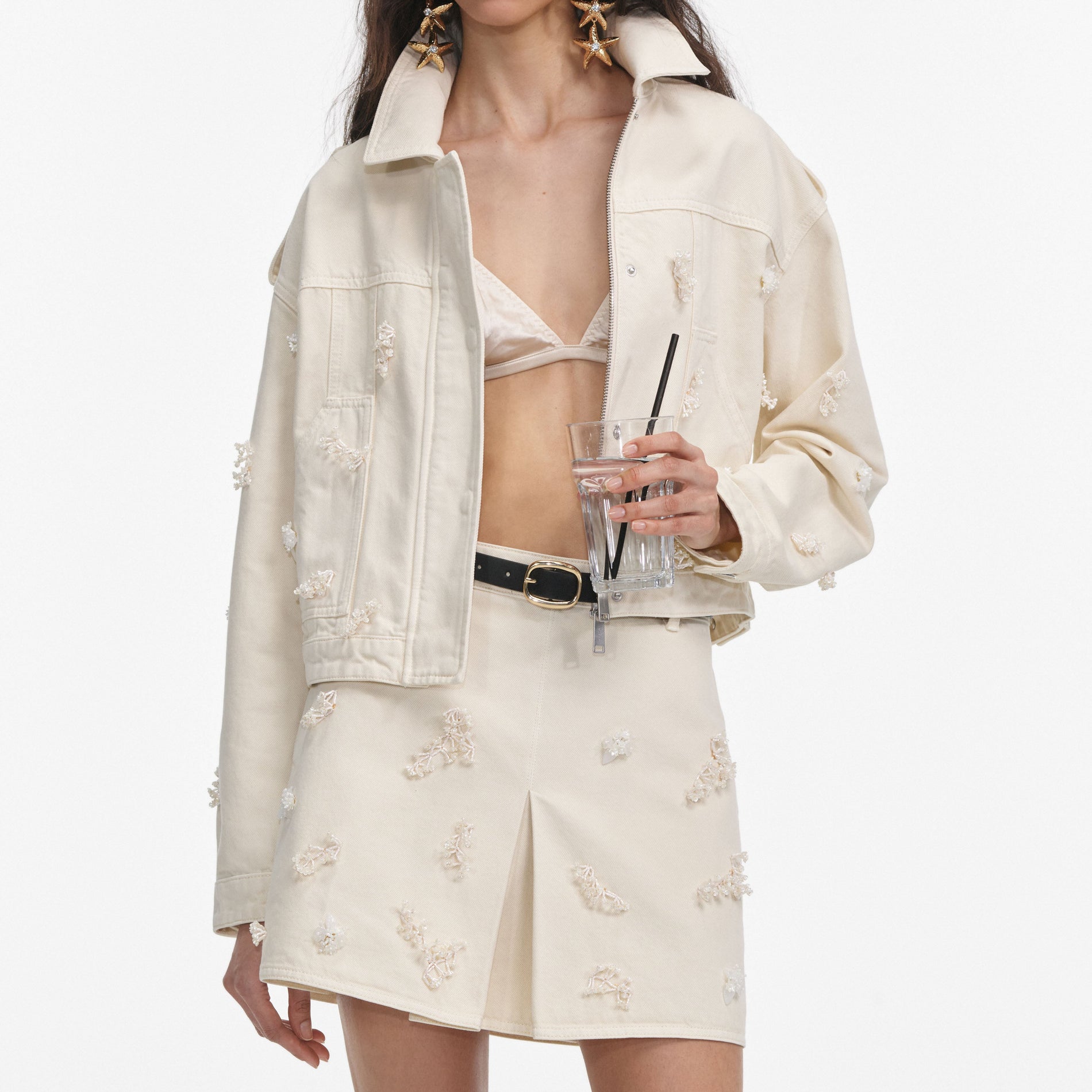 A close up of a woman wearing the Cream Denim Beaded Floral Jacket