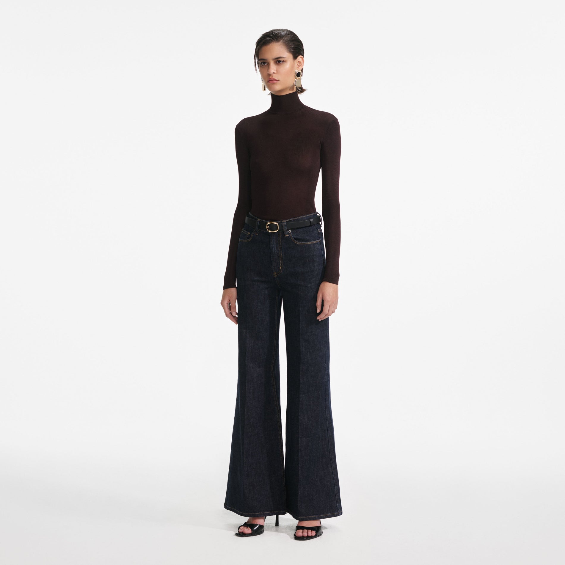 Side view of a woman wearing the Indigo Flared Jeans