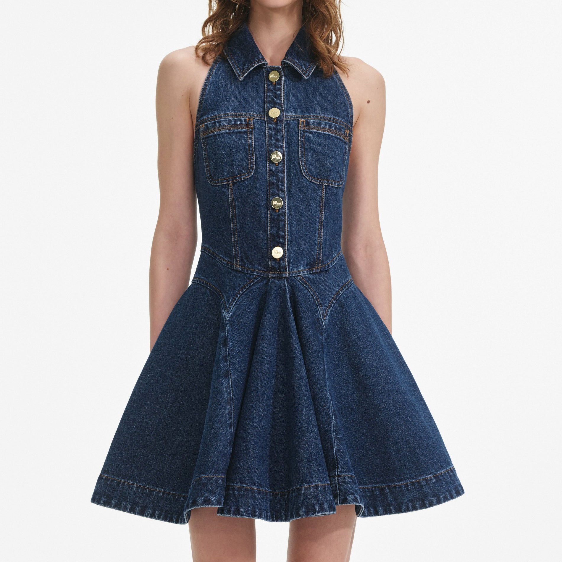 A close up of a woman wearing the Denim Sleeveless Flared Mini Dress
