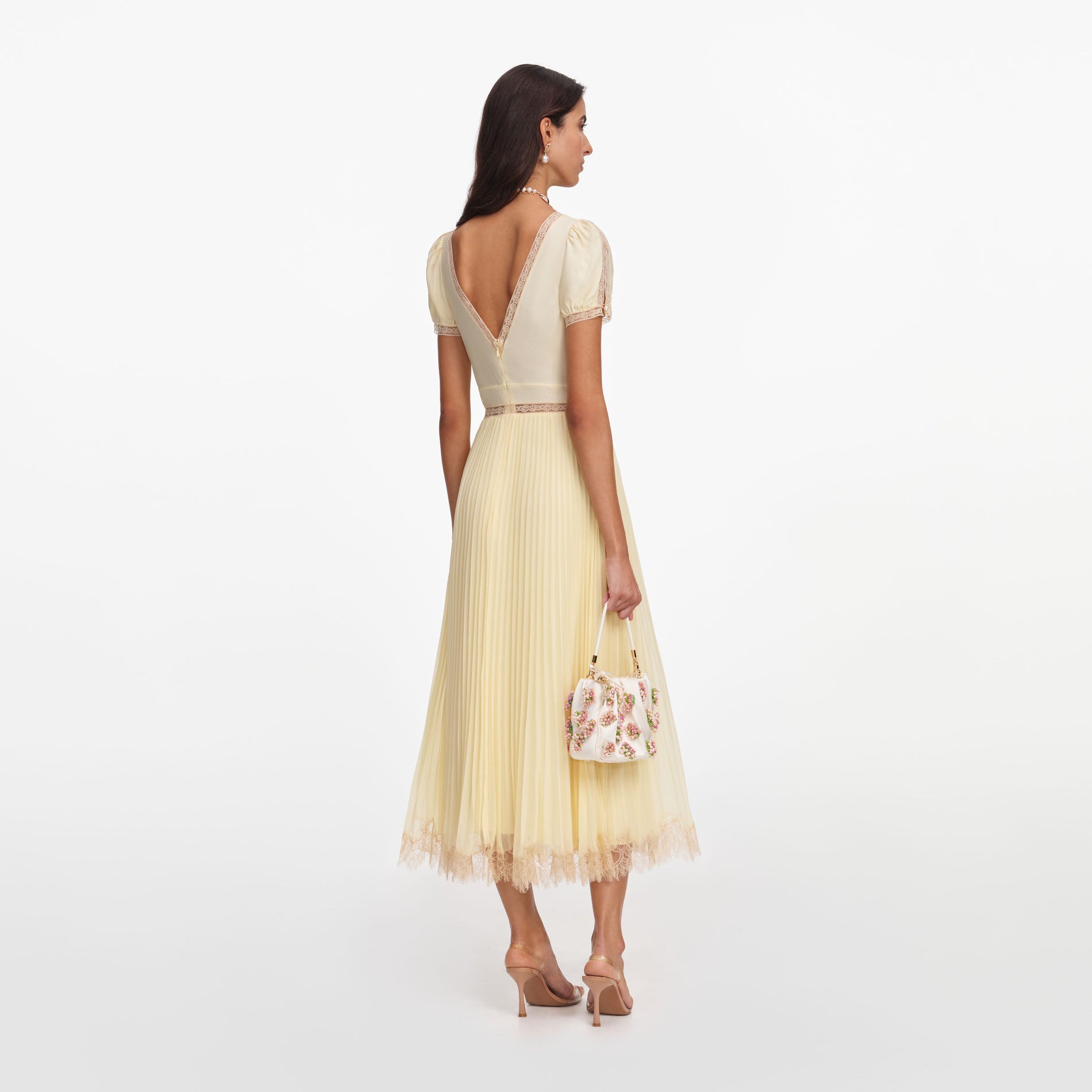 Back view of a woman wearing the Yellow Viscose Pleated Lace Midi Dress