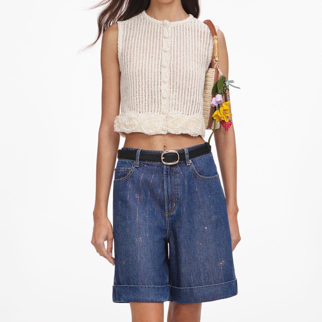 A close up of a woman wearing the Cream Crochet Flower Knit Top