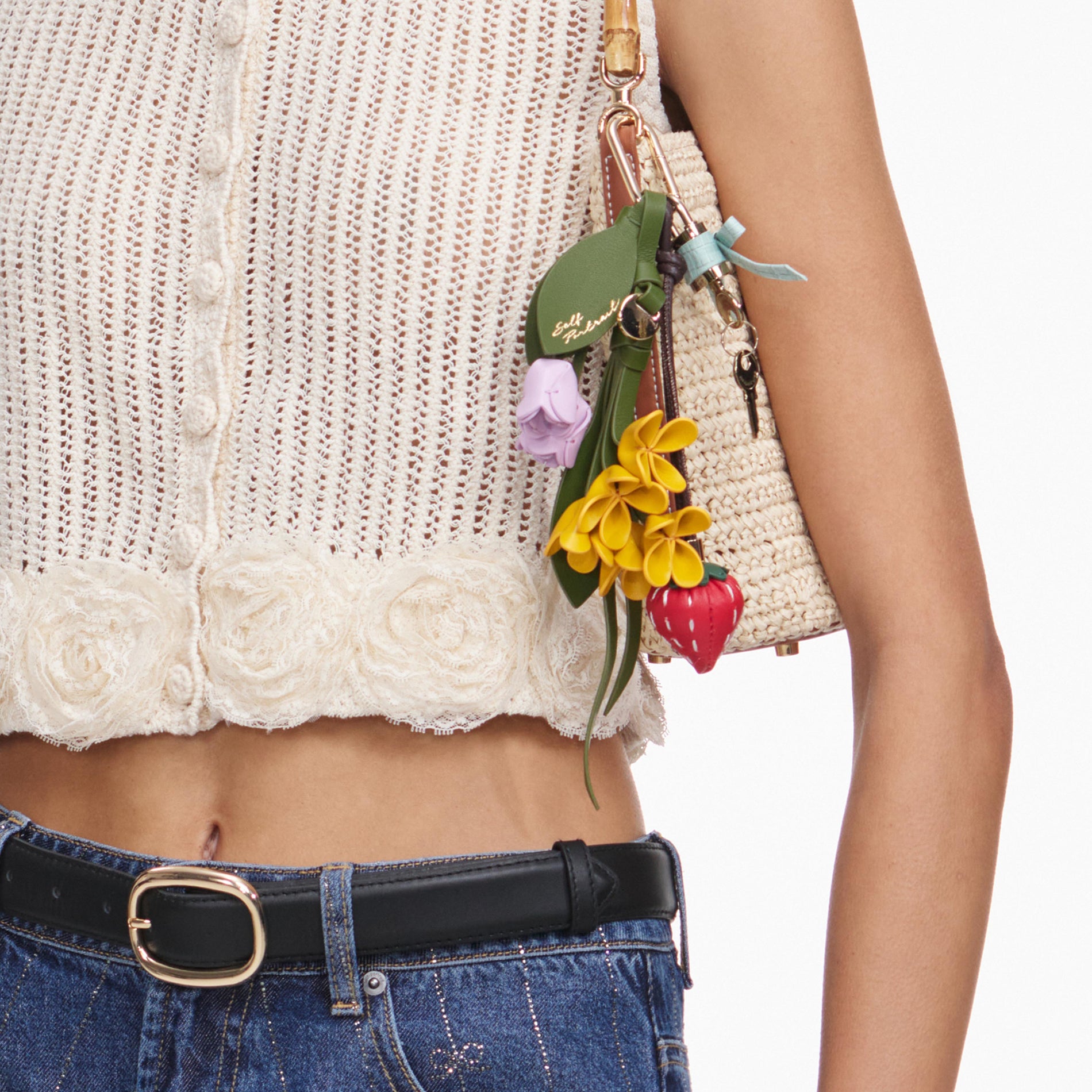 A close up of a woman wearing the Cream Crochet Flower Knit Top