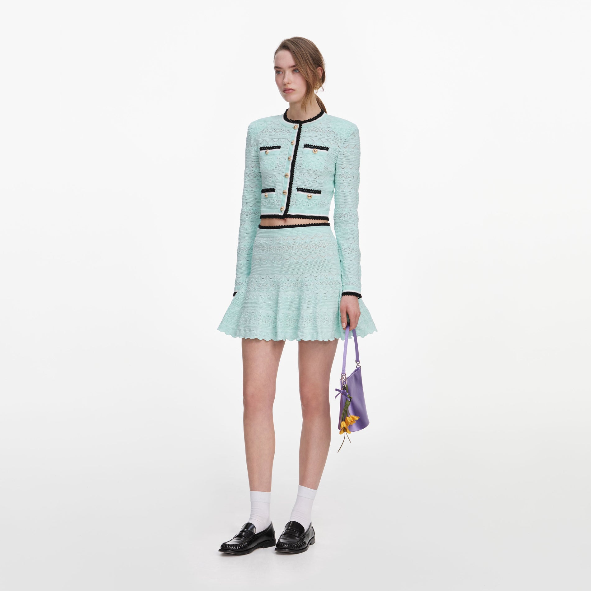 Side view of a woman wearing the Mint Pointelle Knit Mini Skirt