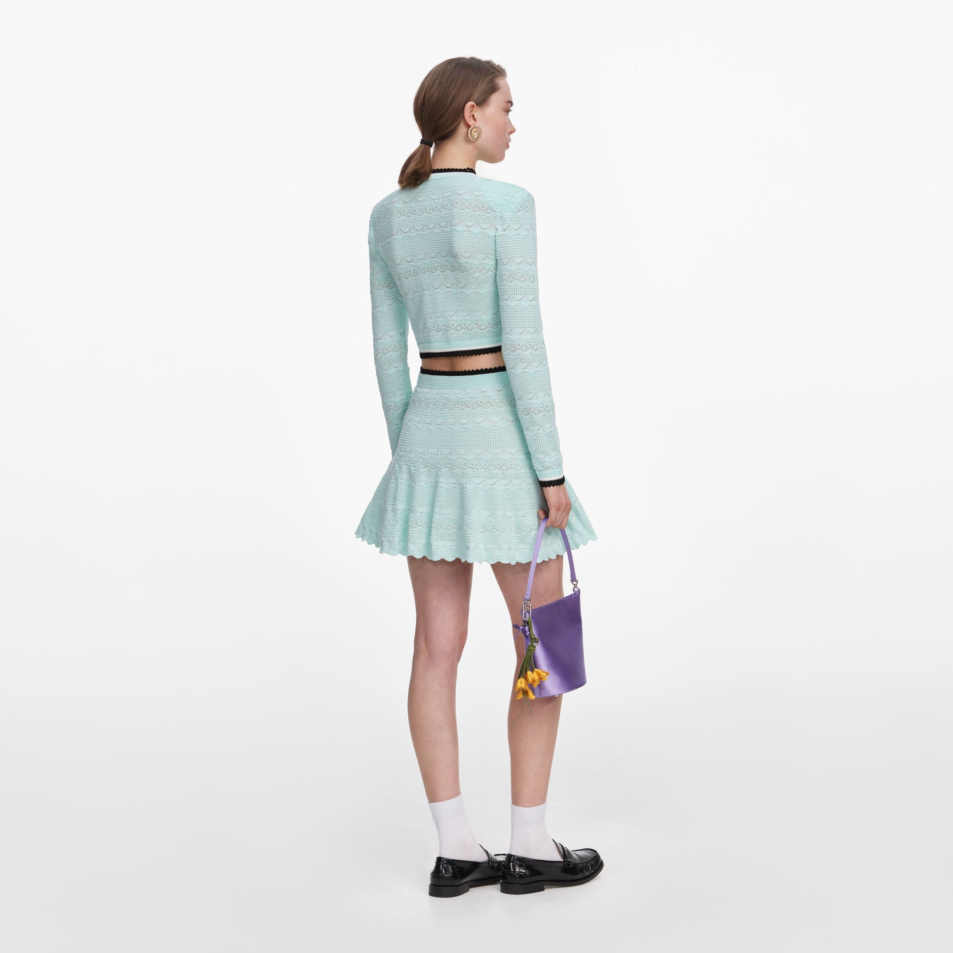 Back view of a woman wearing the Mint Pointelle Knit Mini Skirt