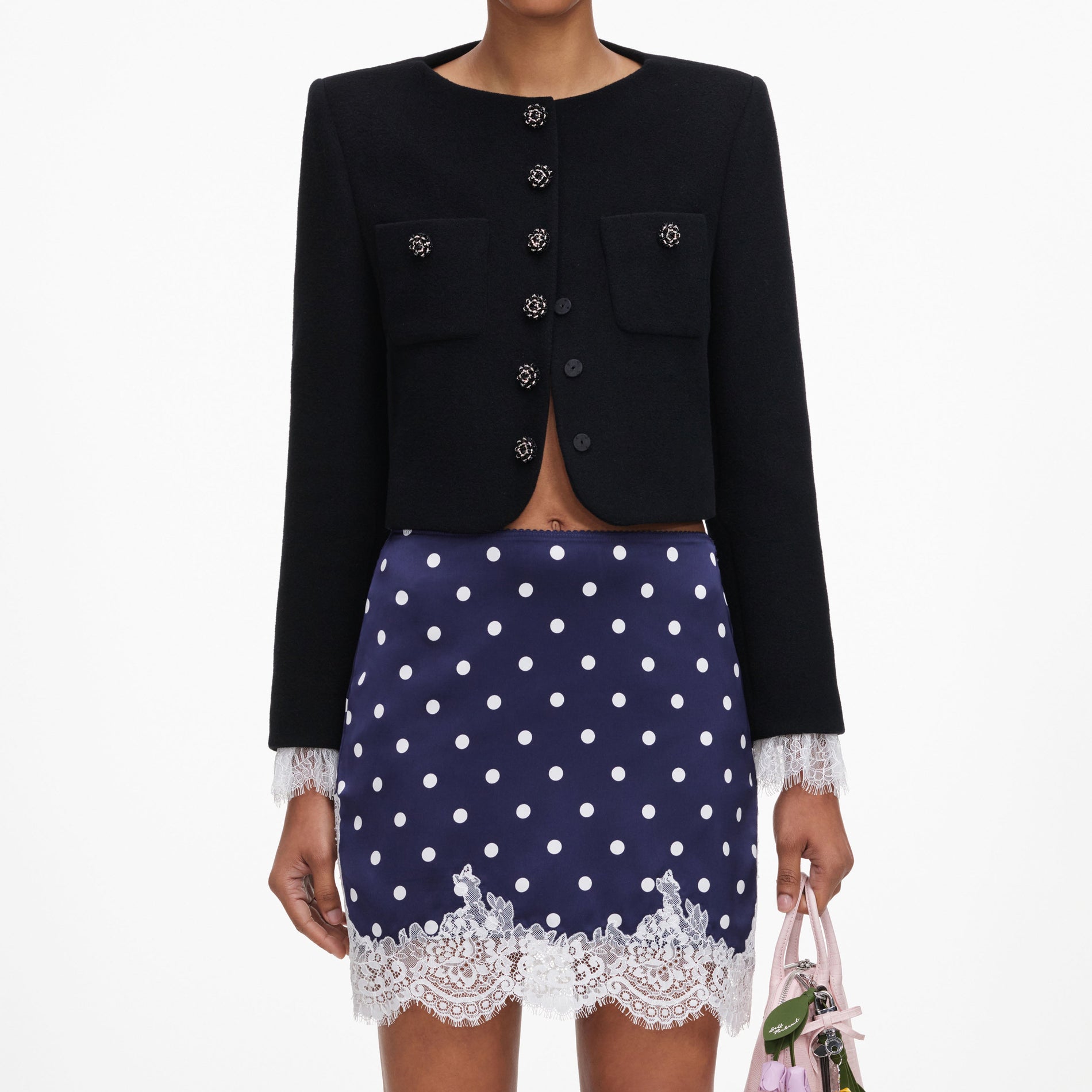 A close up of a woman wearing the Navy Polka Dot Satin Mini Skirt