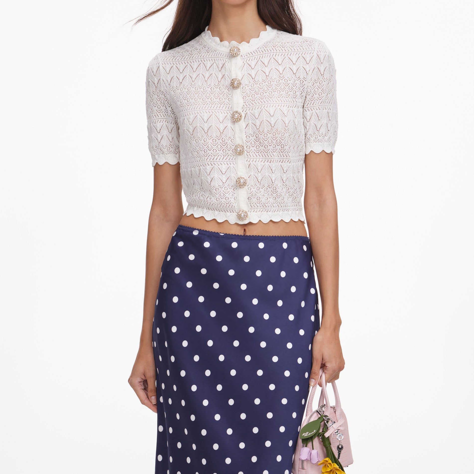 A close up of a woman wearing the White Pointelle Knit Top