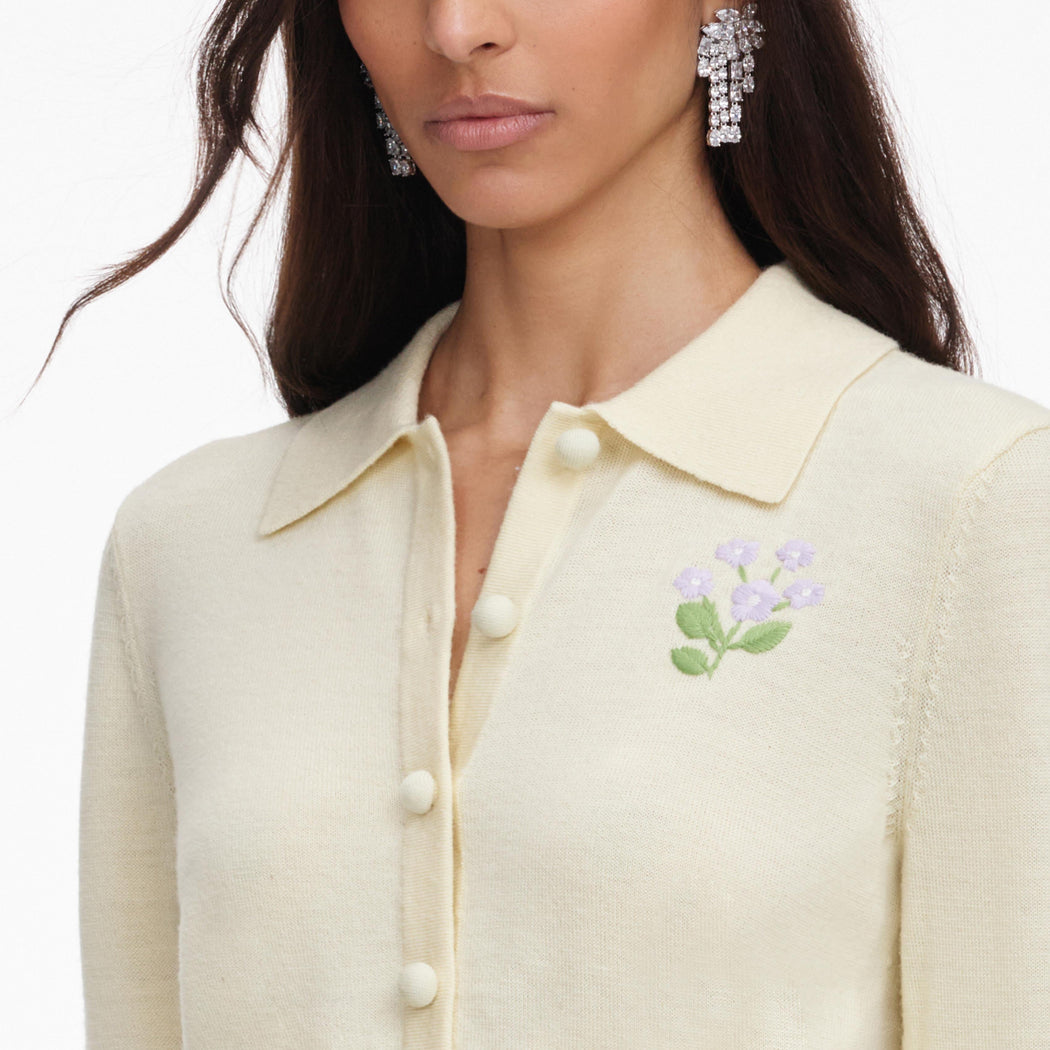A close up of a woman wearing the Yellow Flower Embroidered Knit Cardigan
