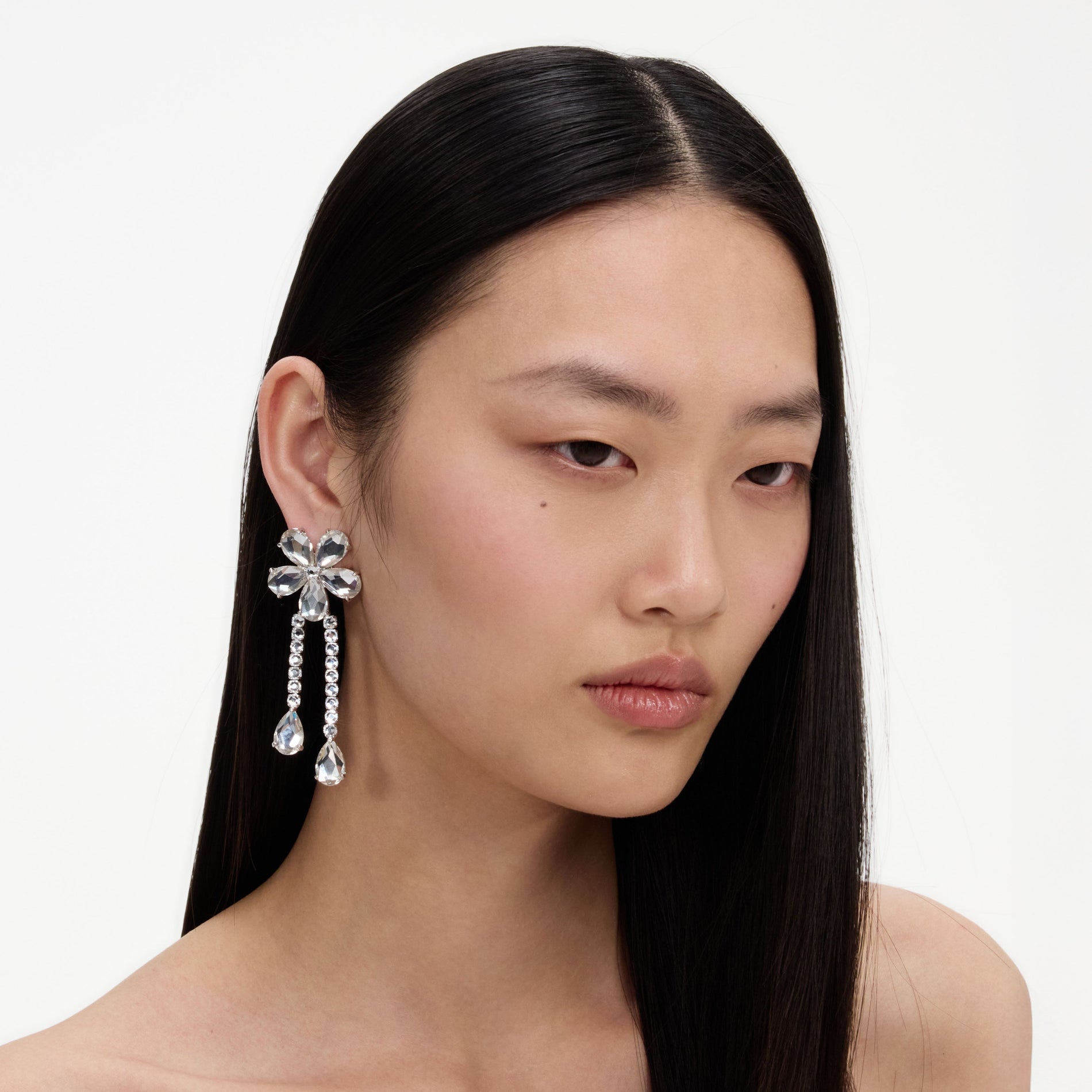 A close up of a woman wearing the Crystal Flower Droplet Earrings