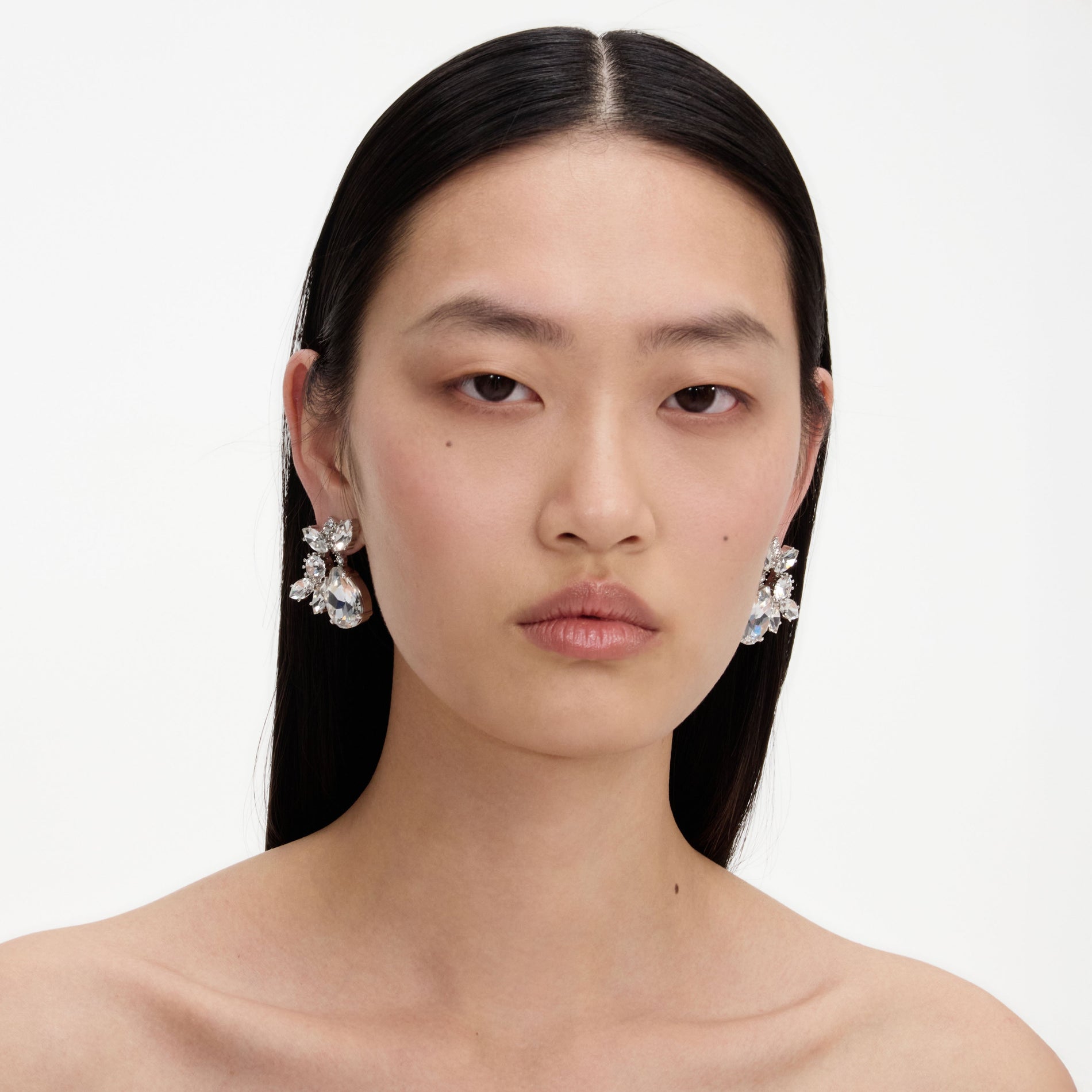 A close up of a woman wearing the Multi Crystal Cluster Earrings