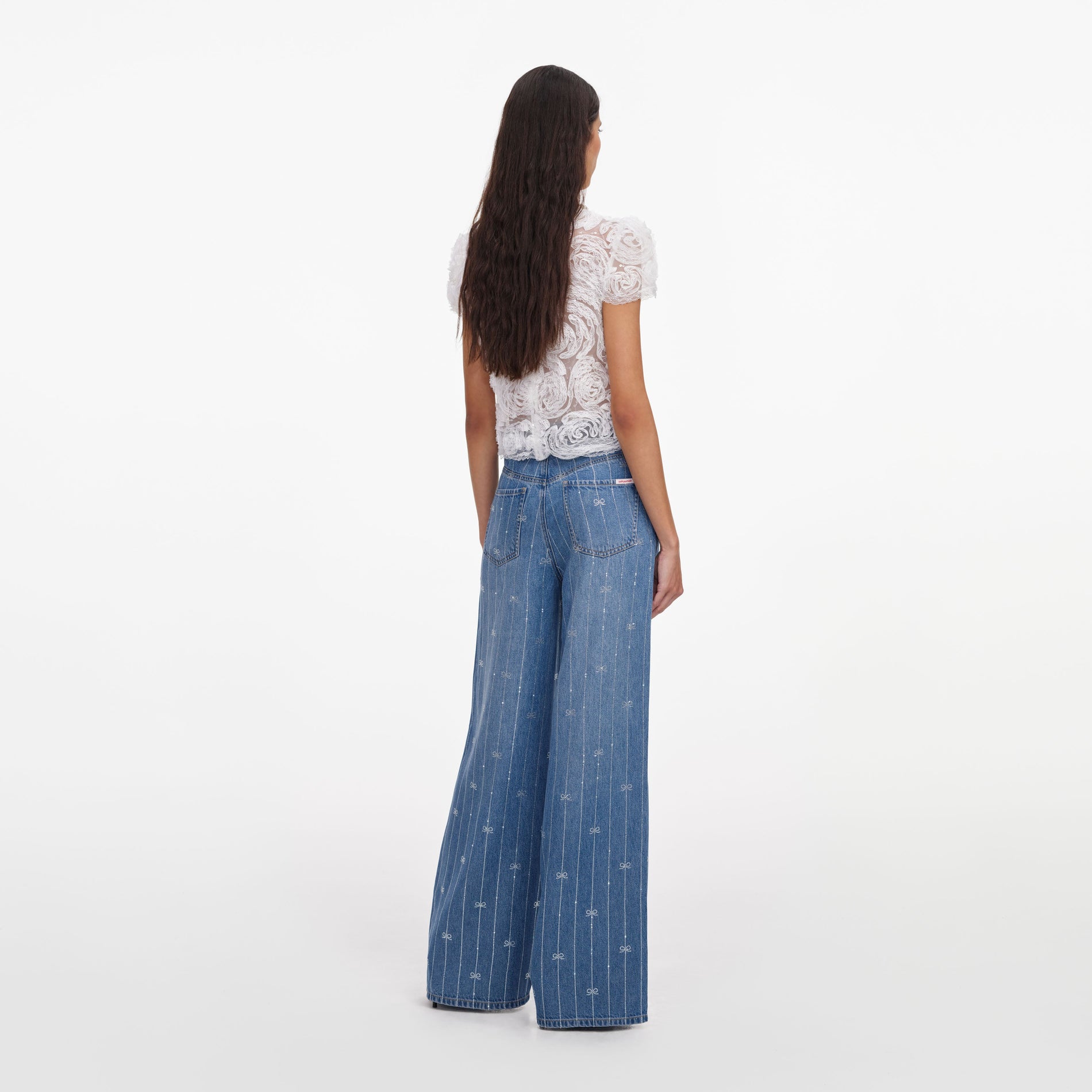 Back view of a woman wearing the Light Blue Rhinestone Stripe Denim Jeans