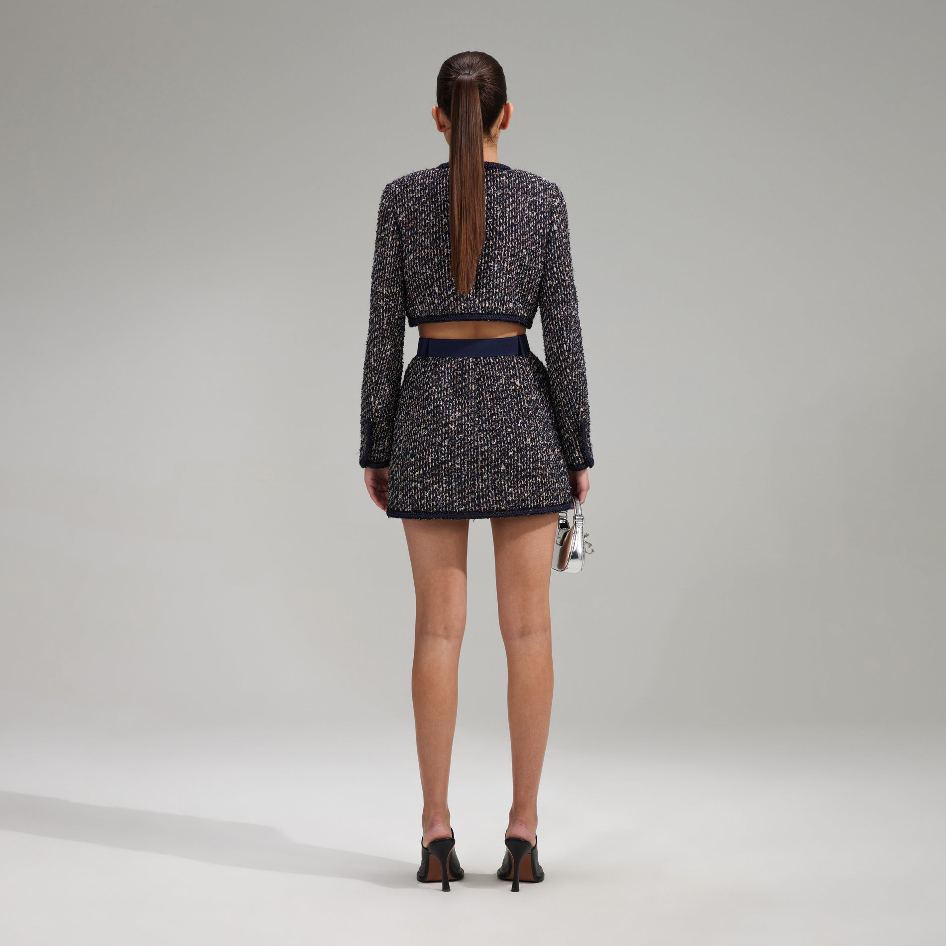 A woman wearing the Boucle Mini Skirt With Braid Detail