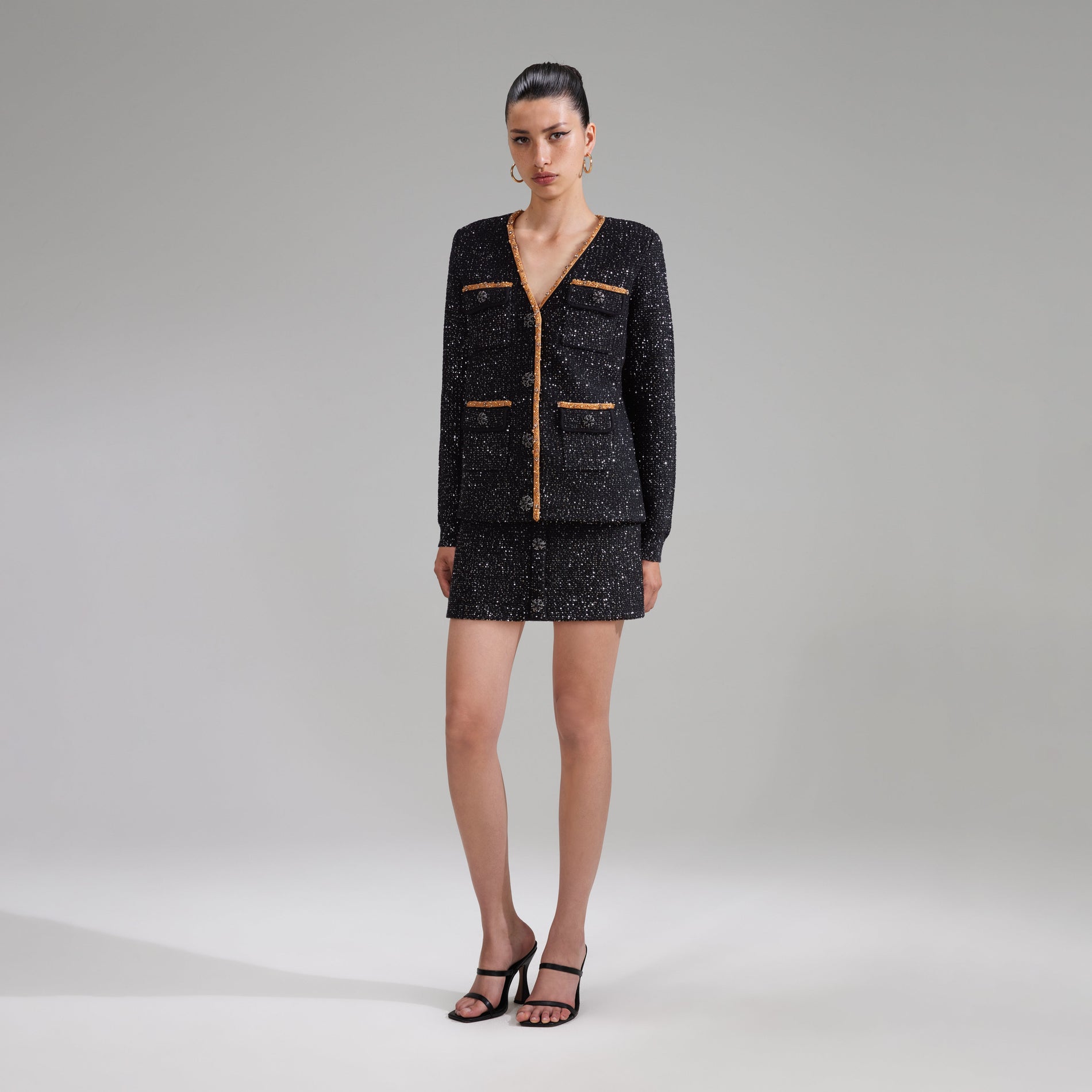 A woman wearing the Black Sequin Knit Cardigan