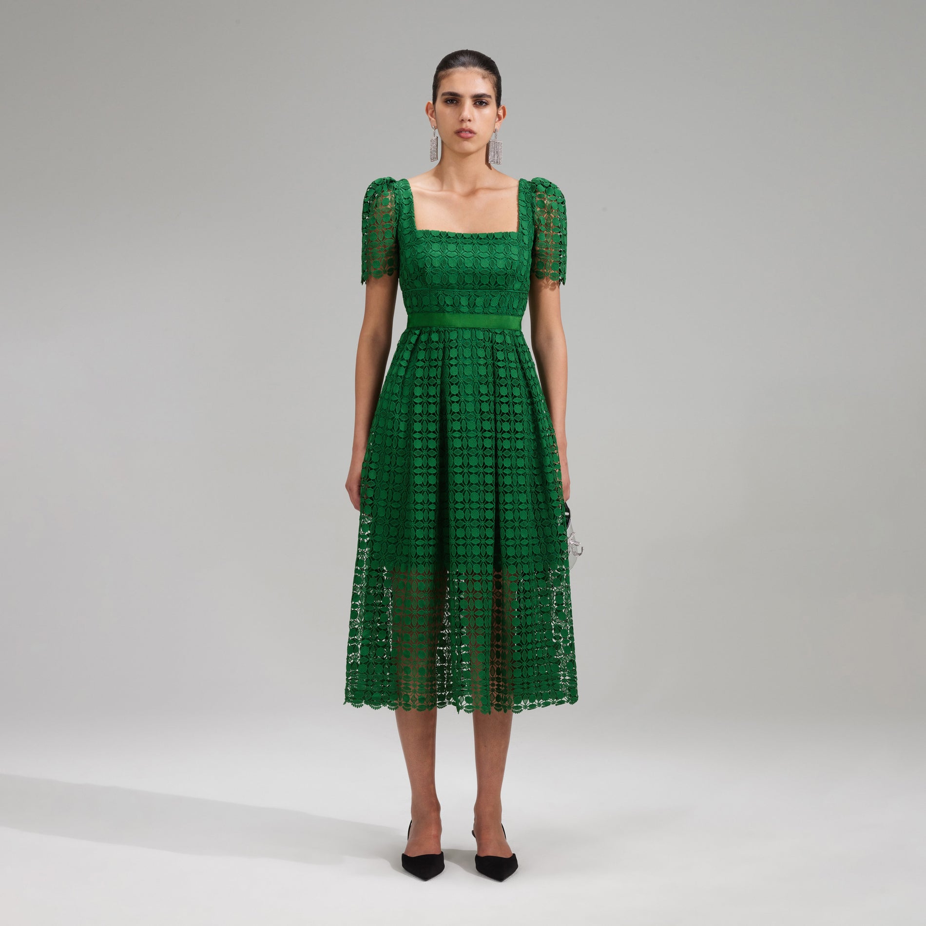 A woman wearing the Green Petal Lace Midi Dress