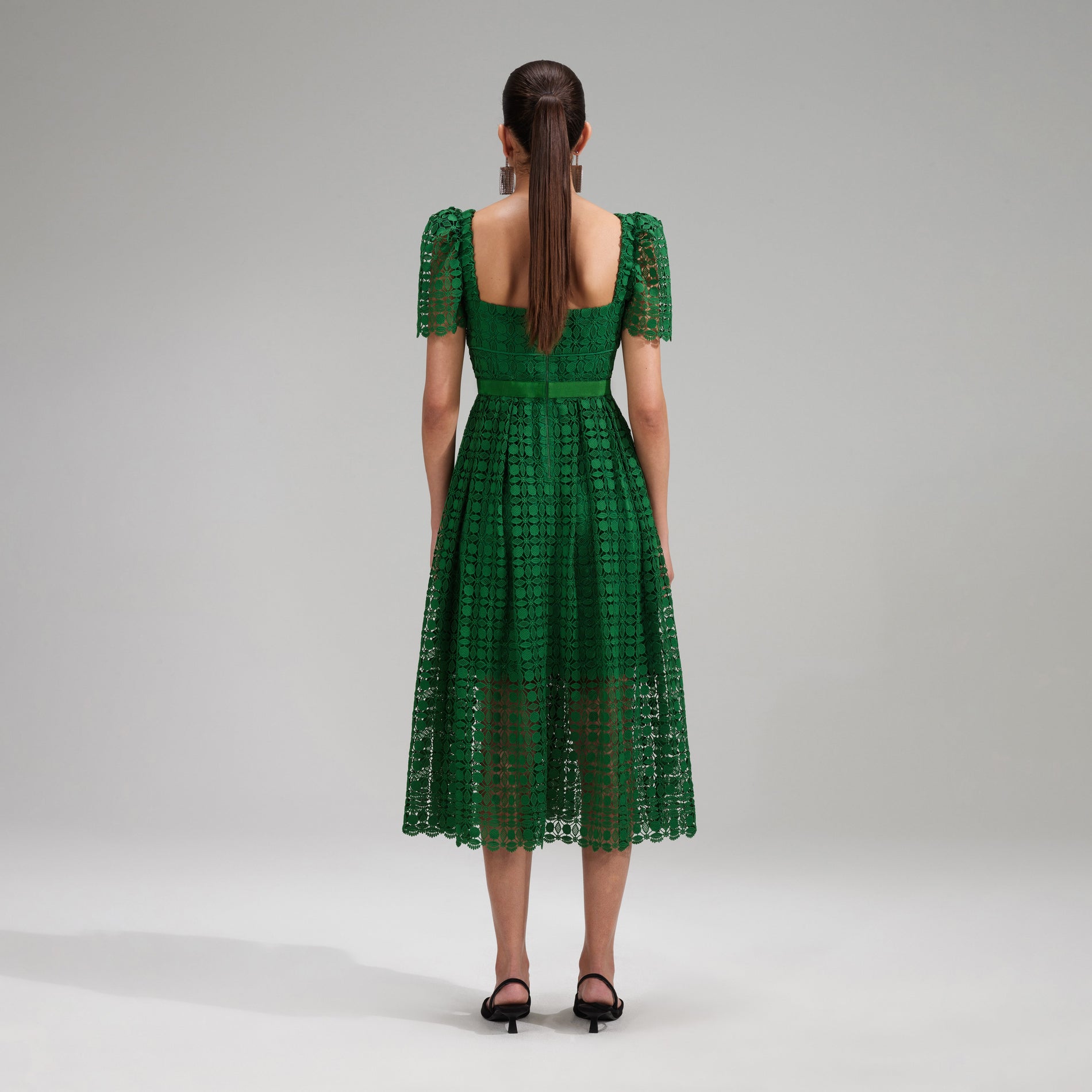 A woman wearing the Green Petal Lace Midi Dress